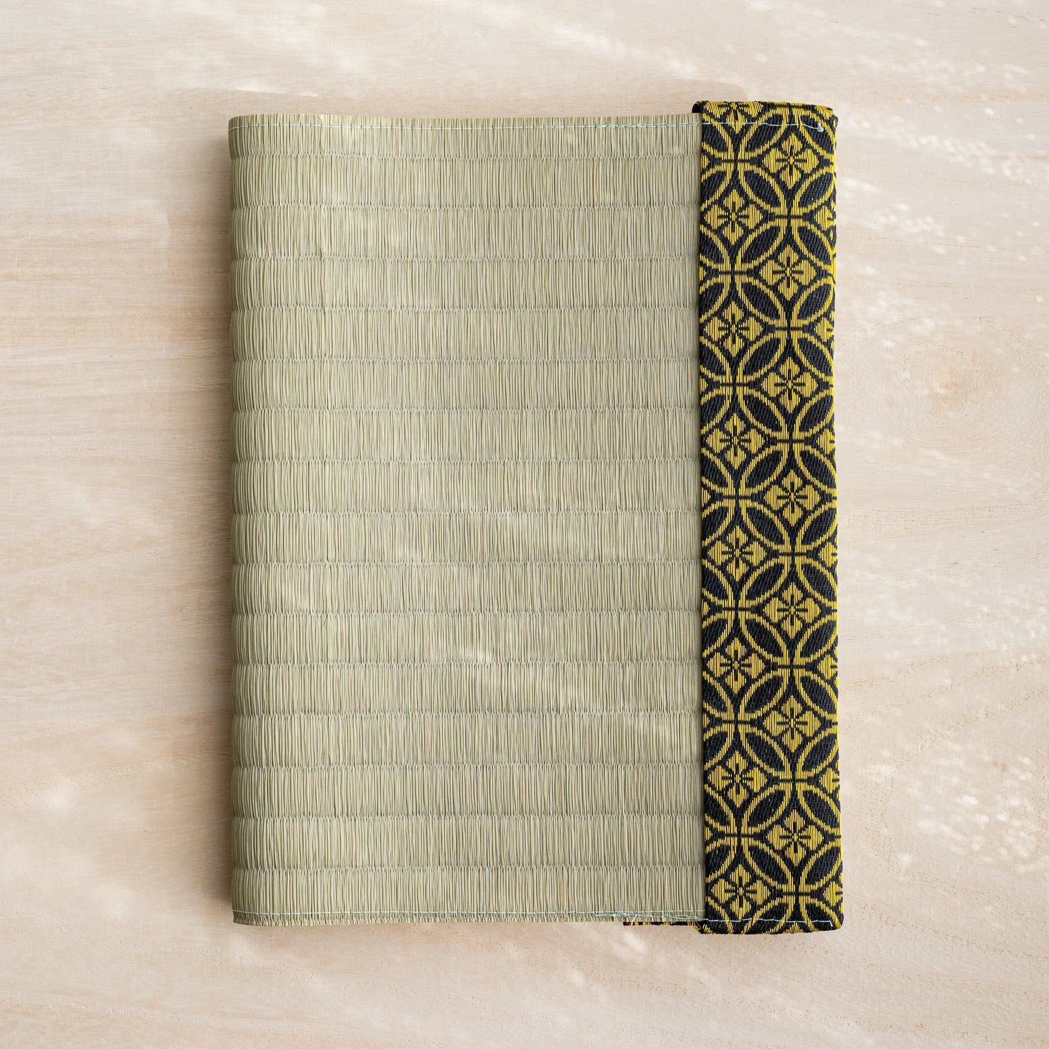 Gold Shippo tatami book cover closed, woven green rush straw with black and gold Japanese shippo circle band at right