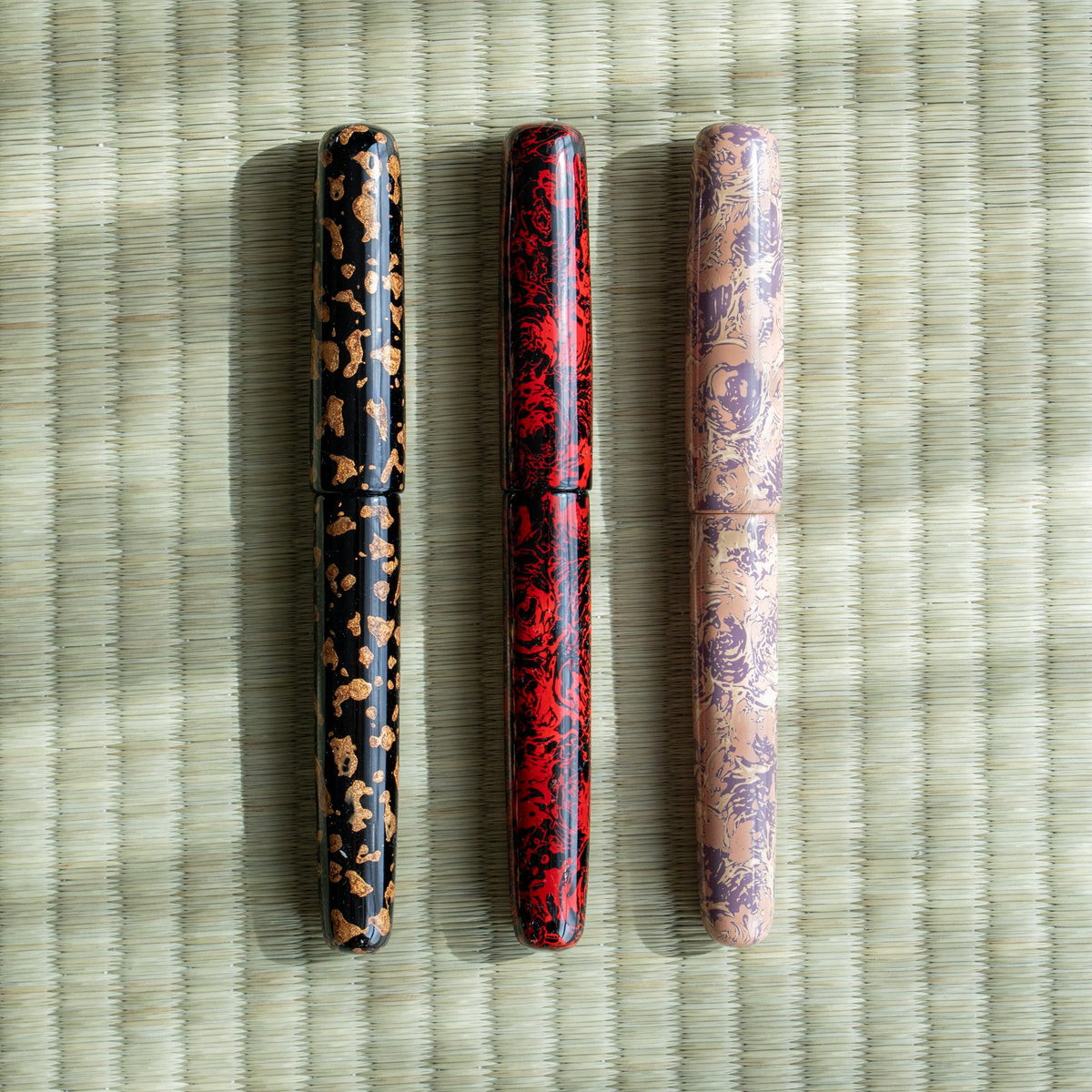 Hoshizukiyo, Kagaribi and Hanagasumi Tsugaru-nuri fountain pens side by side on tatami: black-gold, red-black, pink-purple
