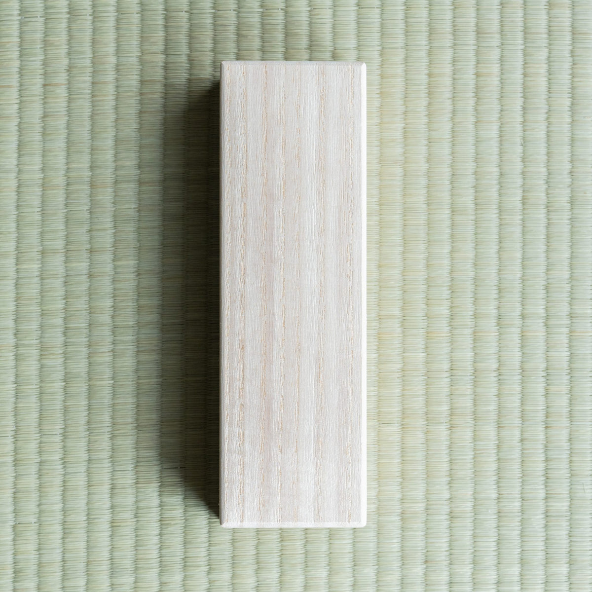 Plain paulownia (kiri) wood box that holds the Tsugaru-nuri urushi fountain pen, on a tatami mat