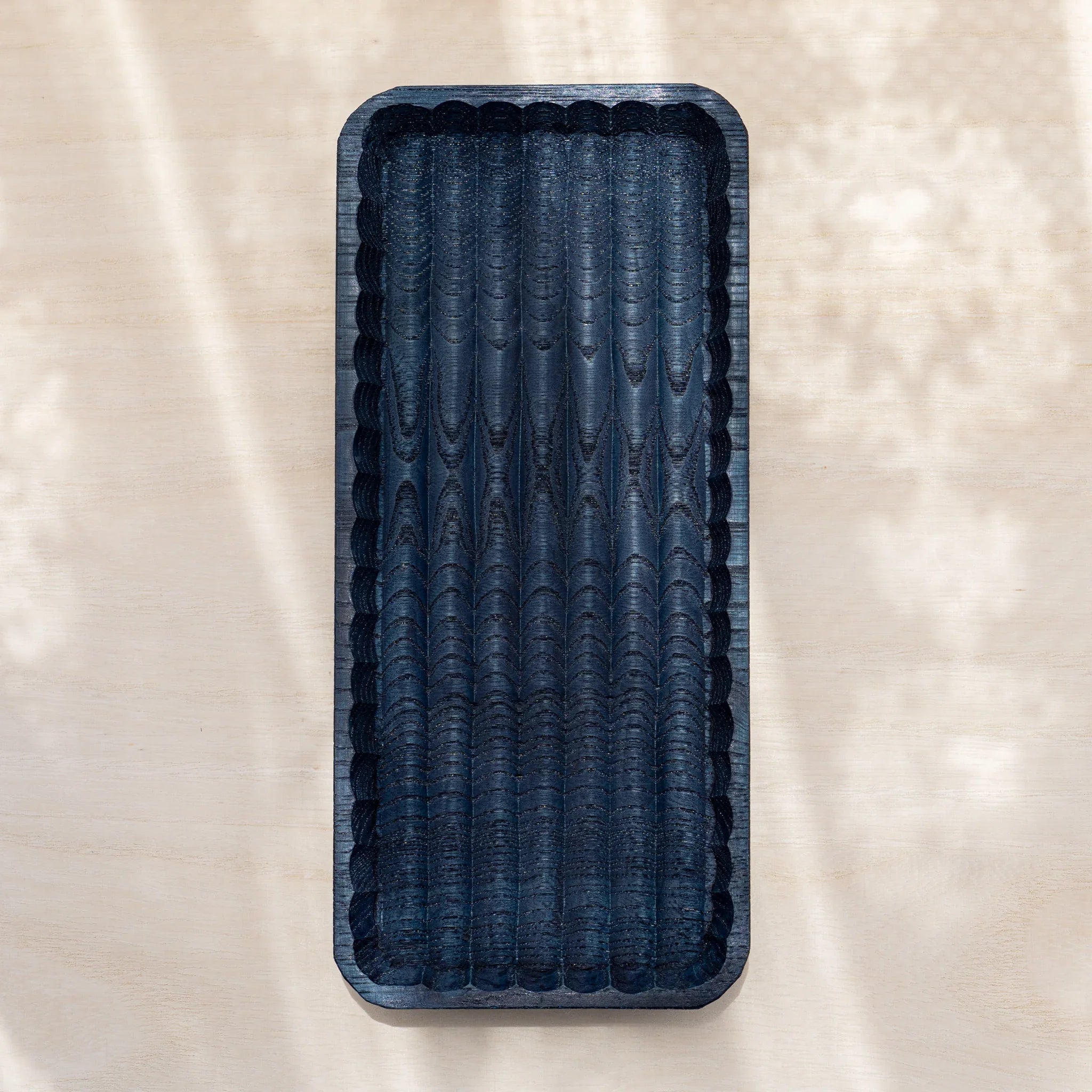 Empty indigo dyed slim Wagatabon chestnut pen tray from above with rows of hand-carved grooves and scalloped rim