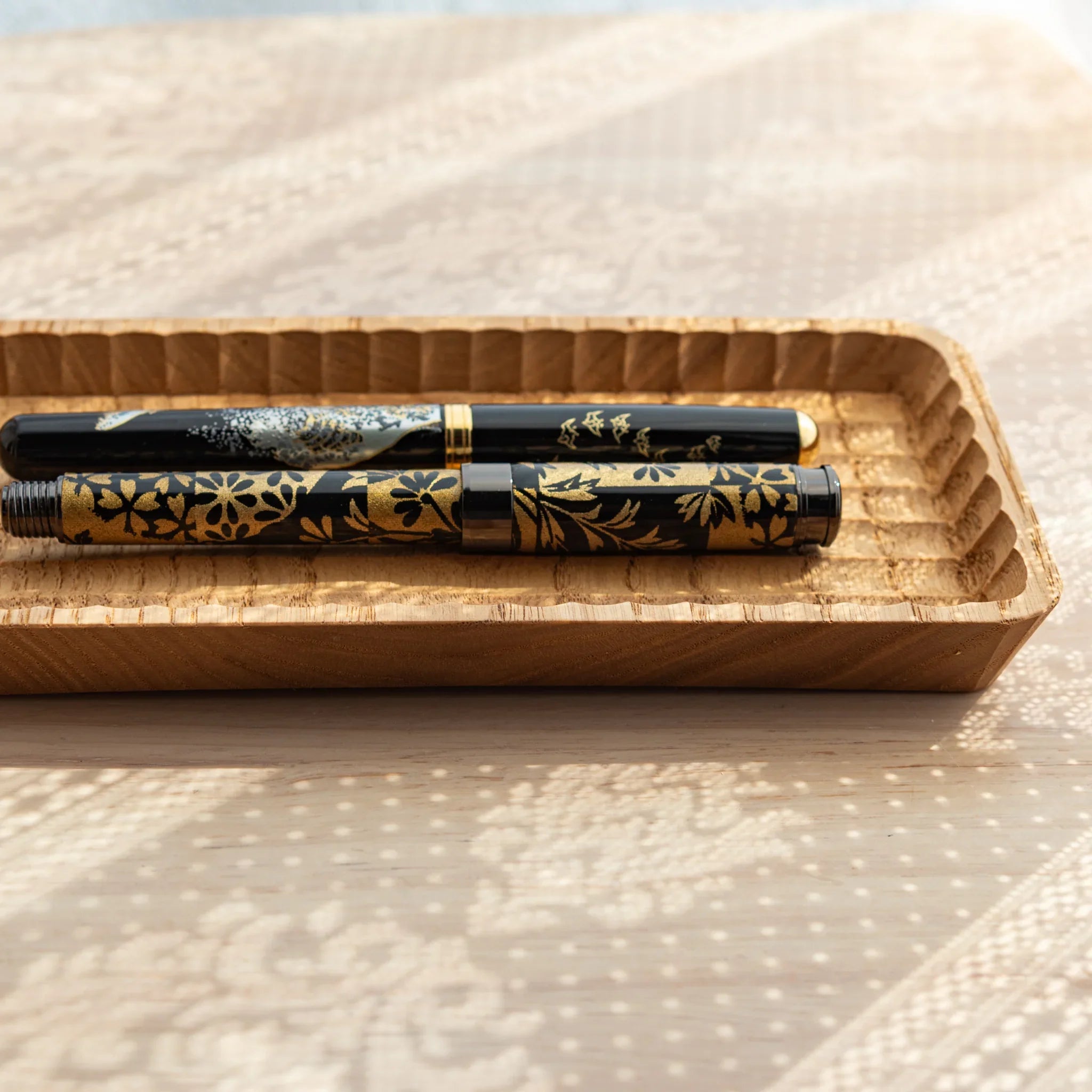 Side view of Japanese Fountain Pens resting in the Hand-Carved Slim Wagatabon Pen Tray.