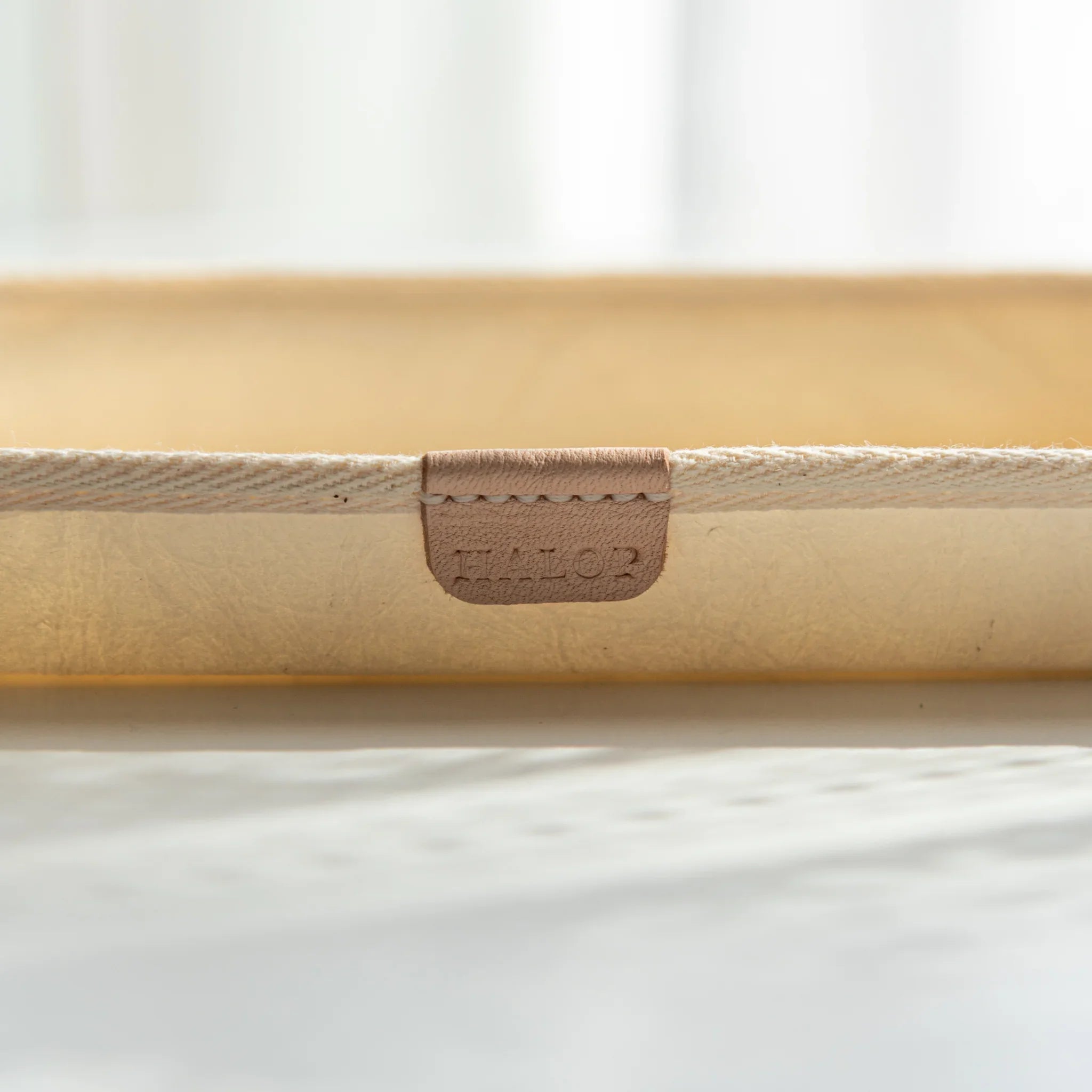 Close-up of natural leather tag with HALOP logo on the white Japanese Pen Tray, blending modern design and tradition.