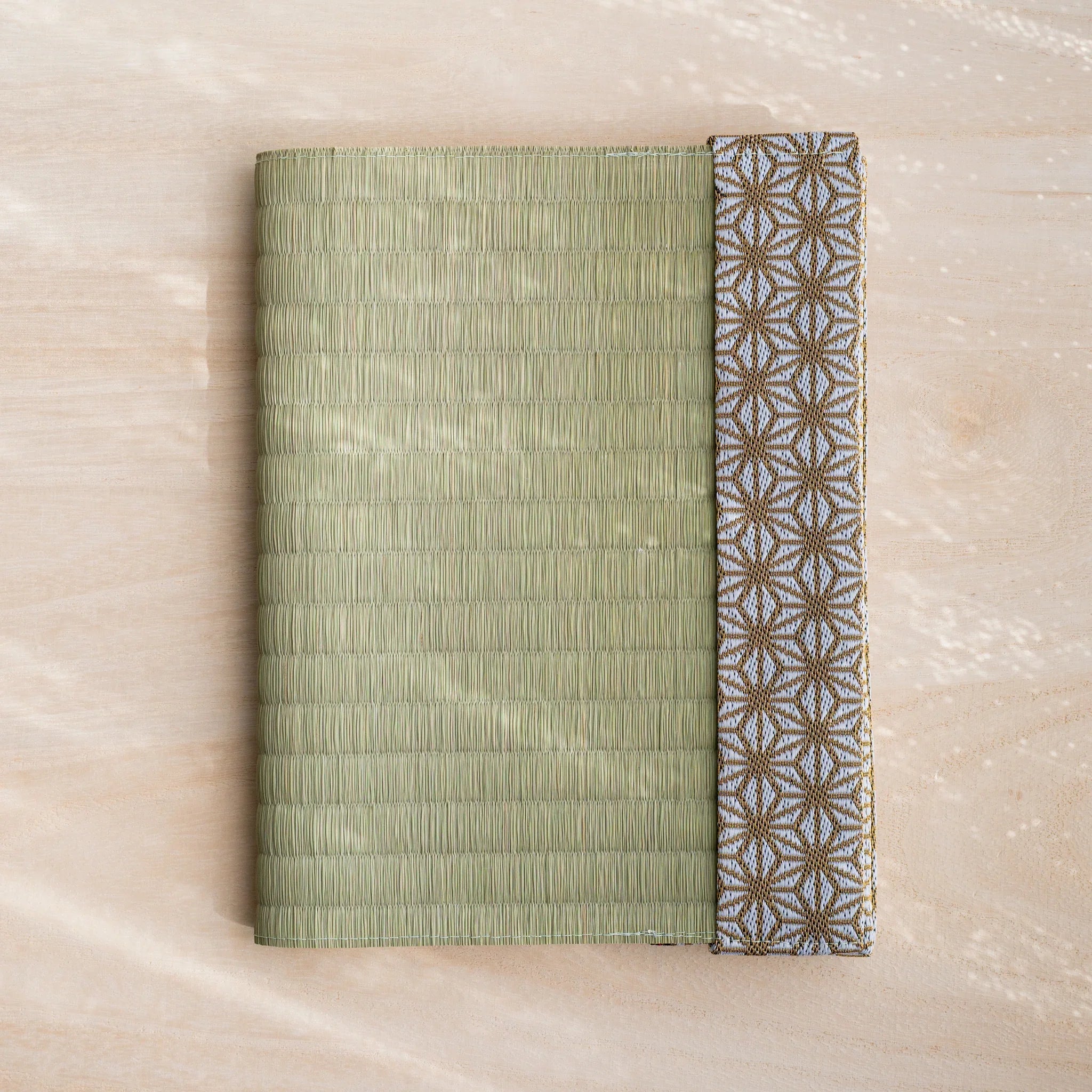 Hemp Leaves tatami book cover closed, woven green rush straw with gold and white Japanese hemp leaf band at right