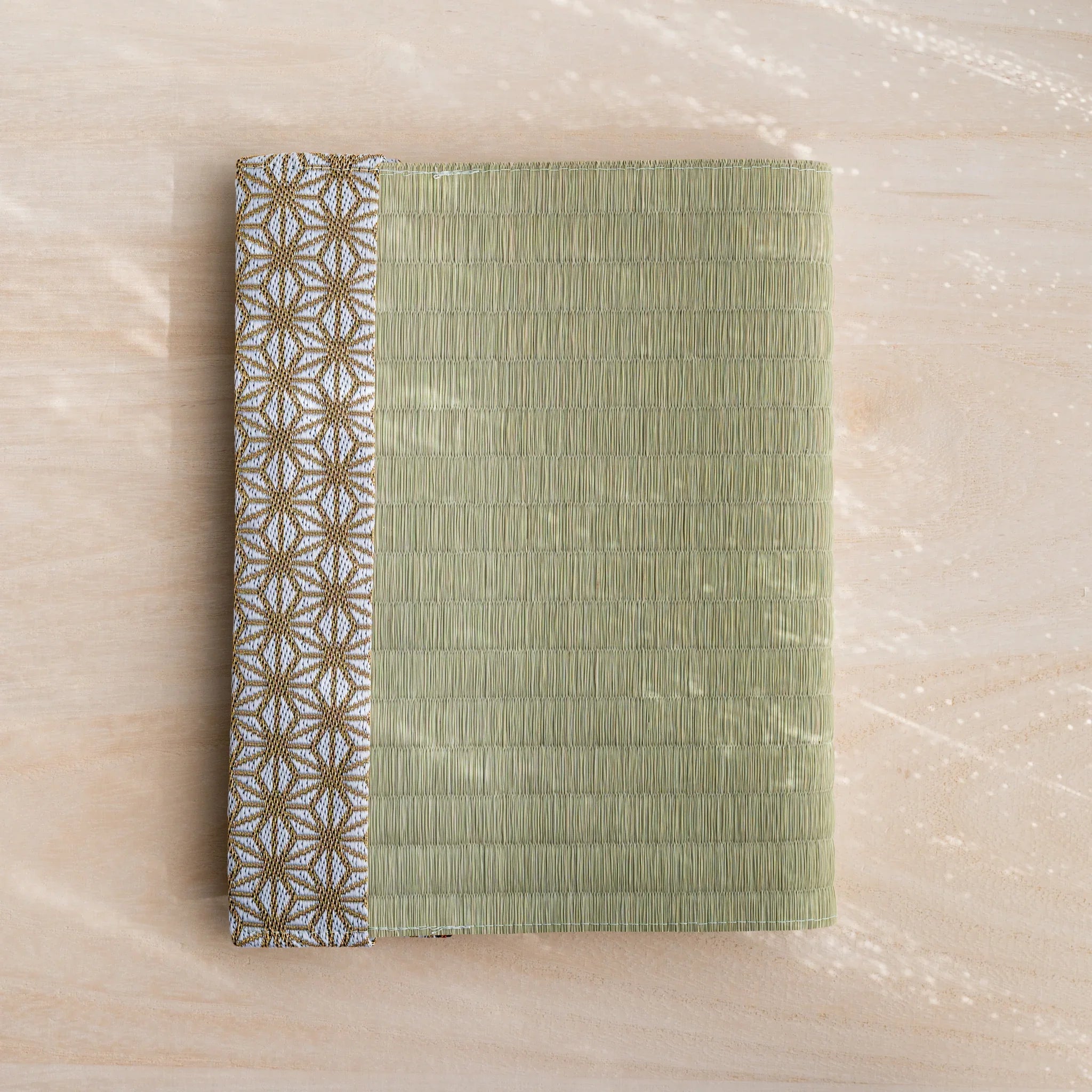 Hemp Leaves tatami book cover closed, woven green rush straw with gold and white Japanese hemp leaf band at left