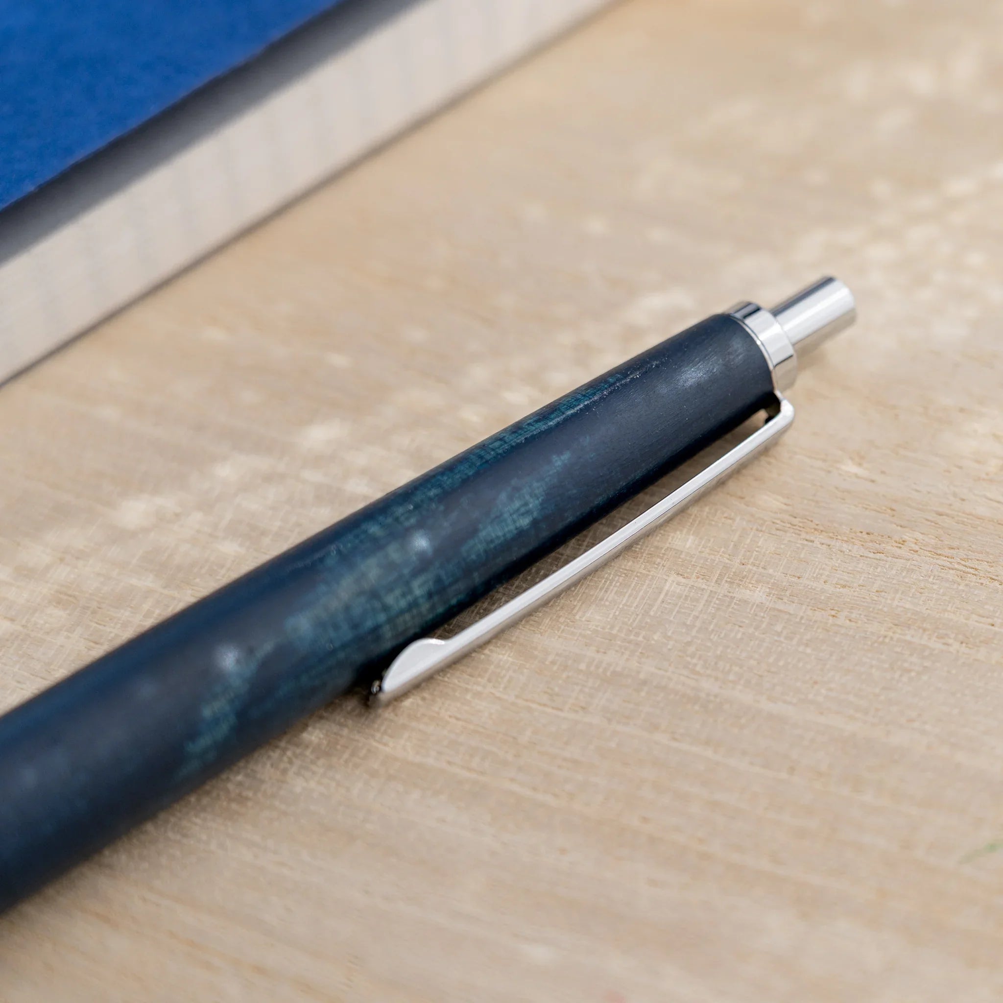 Horse chestnut wood urushi lacquered ballpoint pen in indigo blue, Japanese wood, angled full-body view