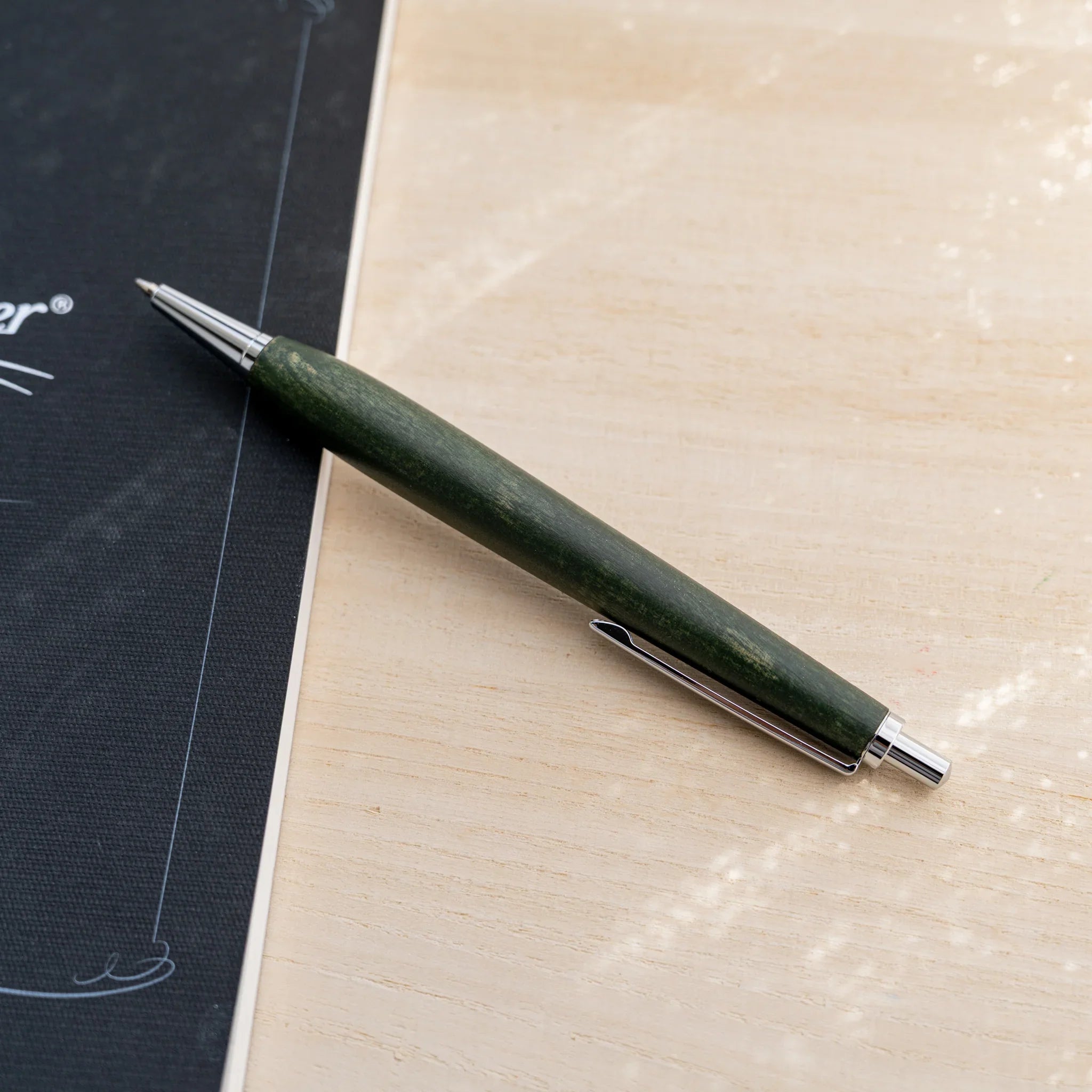 Horse chestnut wood urushi lacquered ballpoint pen in olive green, Japanese wood, angled full-body view