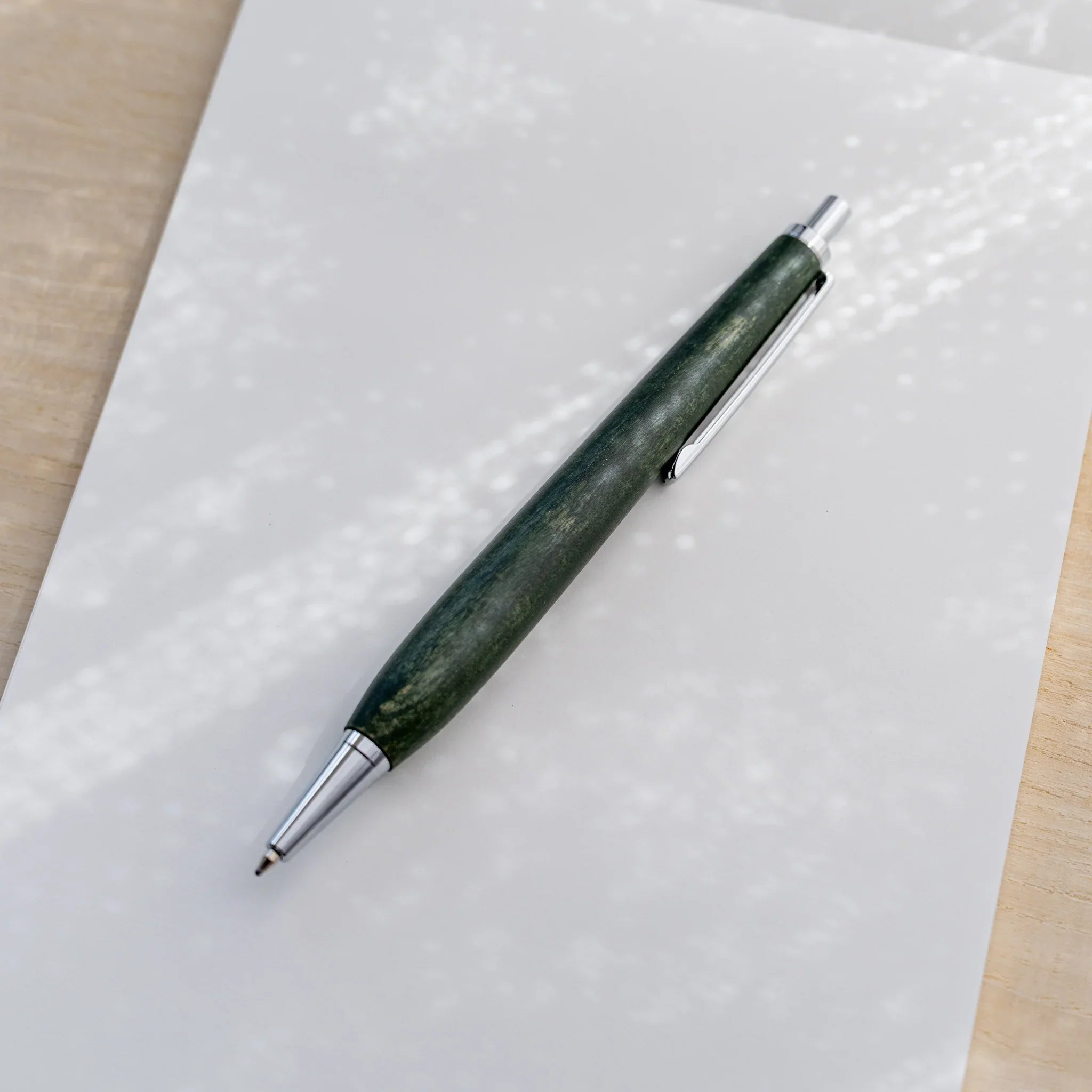 Olive green horse chestnut wood urushi ballpoint pen, close-up of knock end and silver clip, Japanese wood