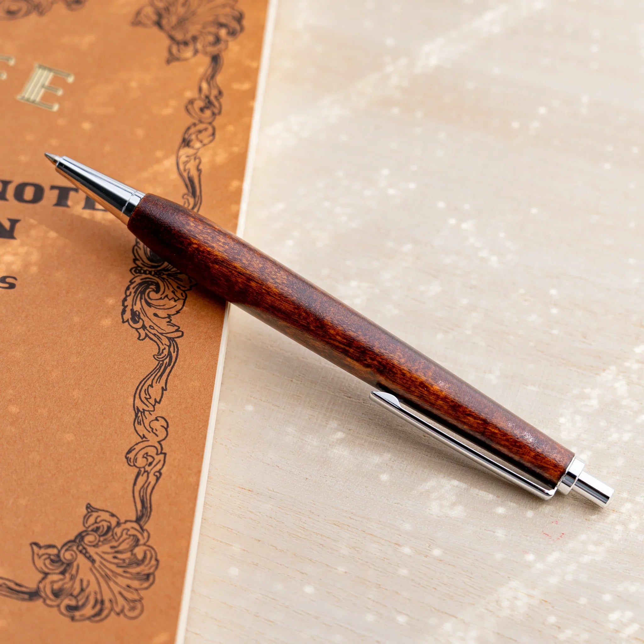 Horse chestnut wood urushi lacquered ballpoint pen in amber-brown, Japanese wood, angled full-body view