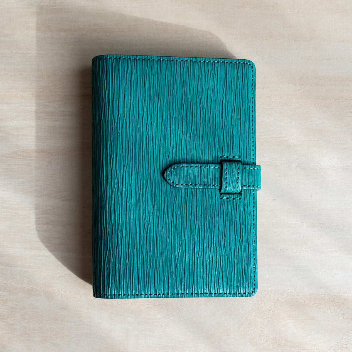 Ise Gikakushi paper leather planner, Mini 6 size in teal, front cover with creases and strap