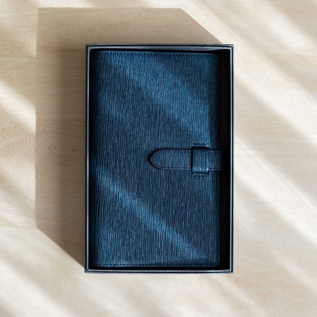 Navy Ise Gikakushi paper leather planner inside its open gray gift box