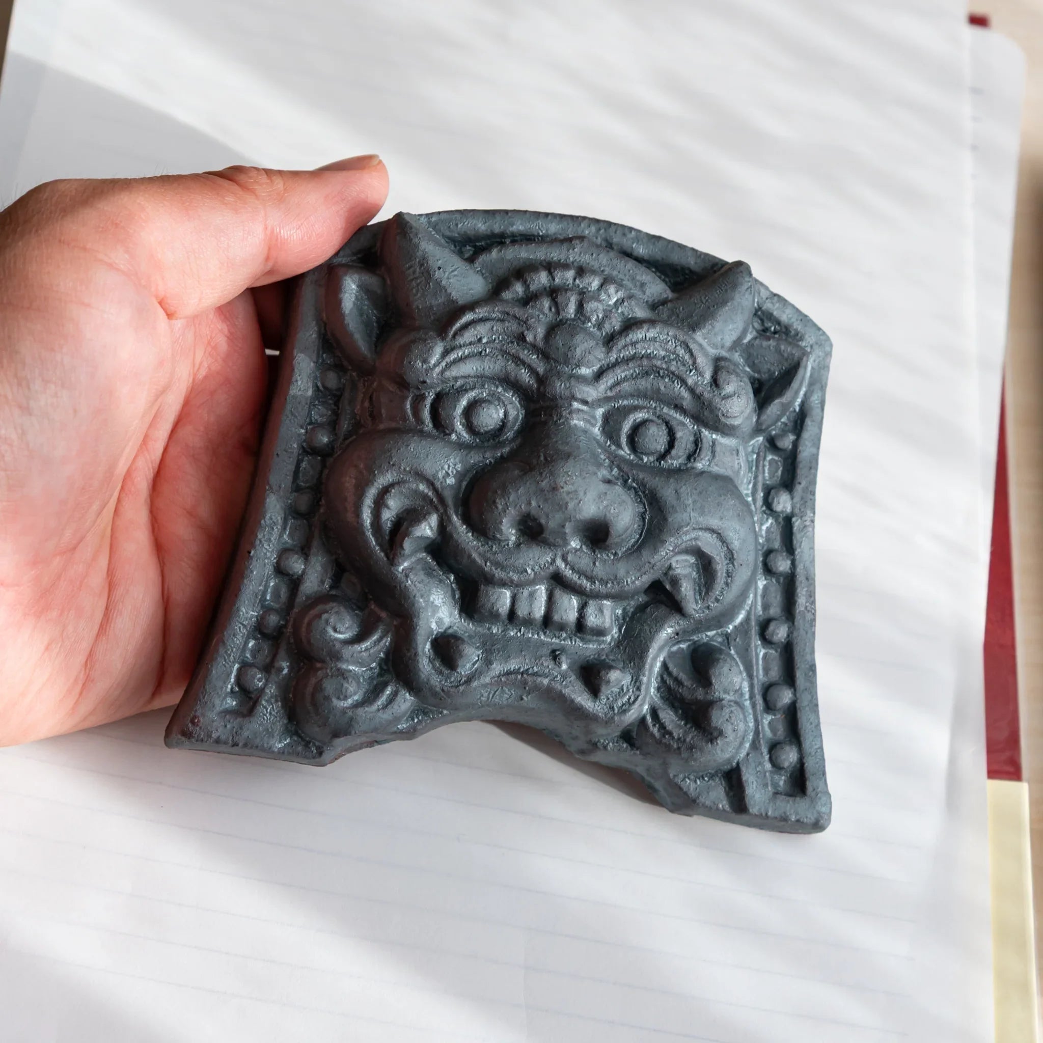 Japanese Paperweight Desk Accessory held in hand shows resolute oni roof guardian tile's texture and scale.