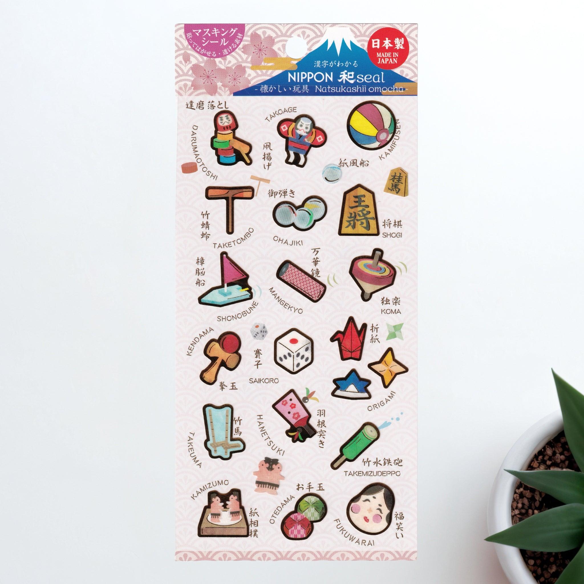 A Japanese stationery washi sticker sheet featuring nostalgic Japanese toys, including kendama, koma, origami, otedama, and ohajiki, beautifully illustrated with a retro charm.