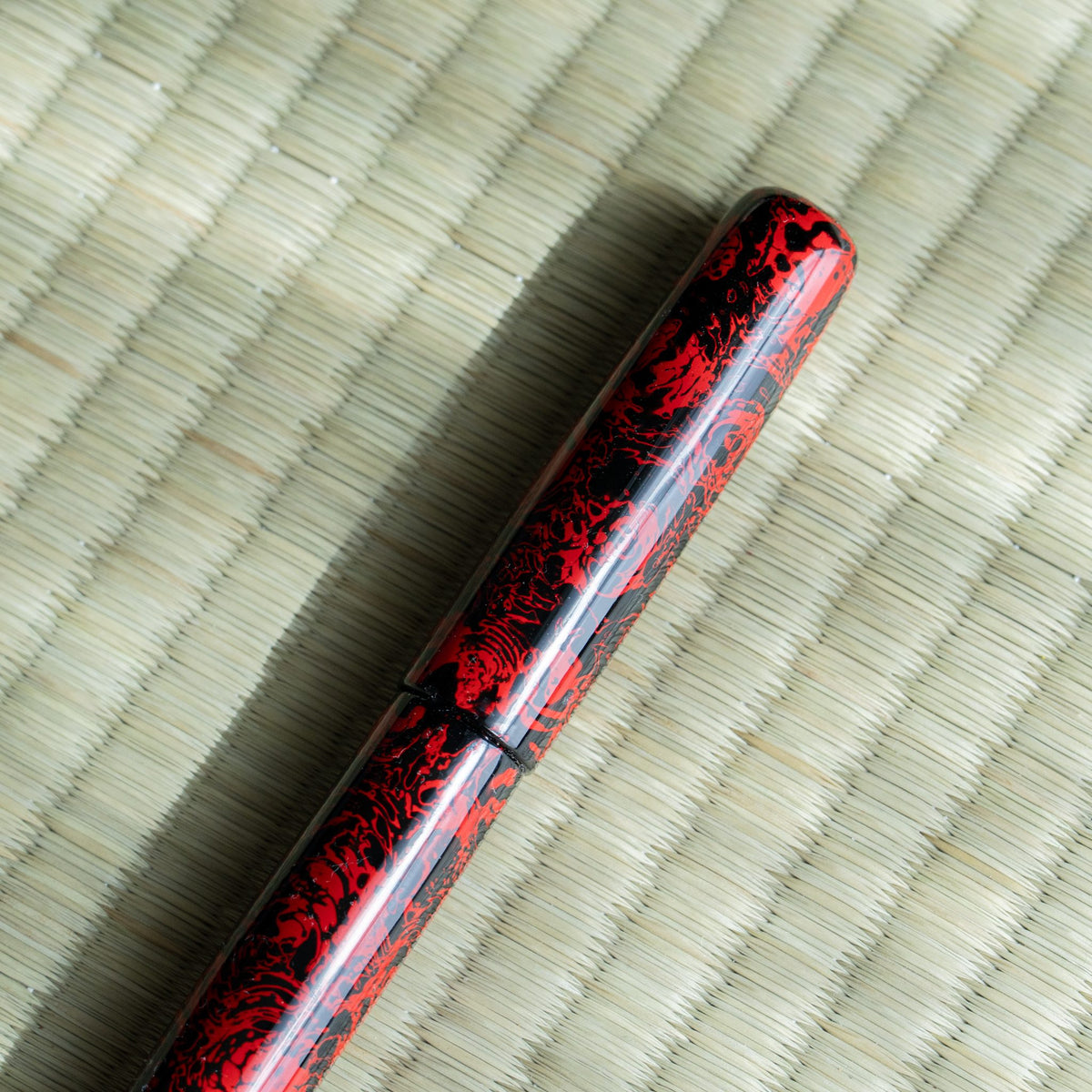 Close-up of the Kagaribi cap, glossy red and black Tsugaru-nuri lacquer and the cap joint