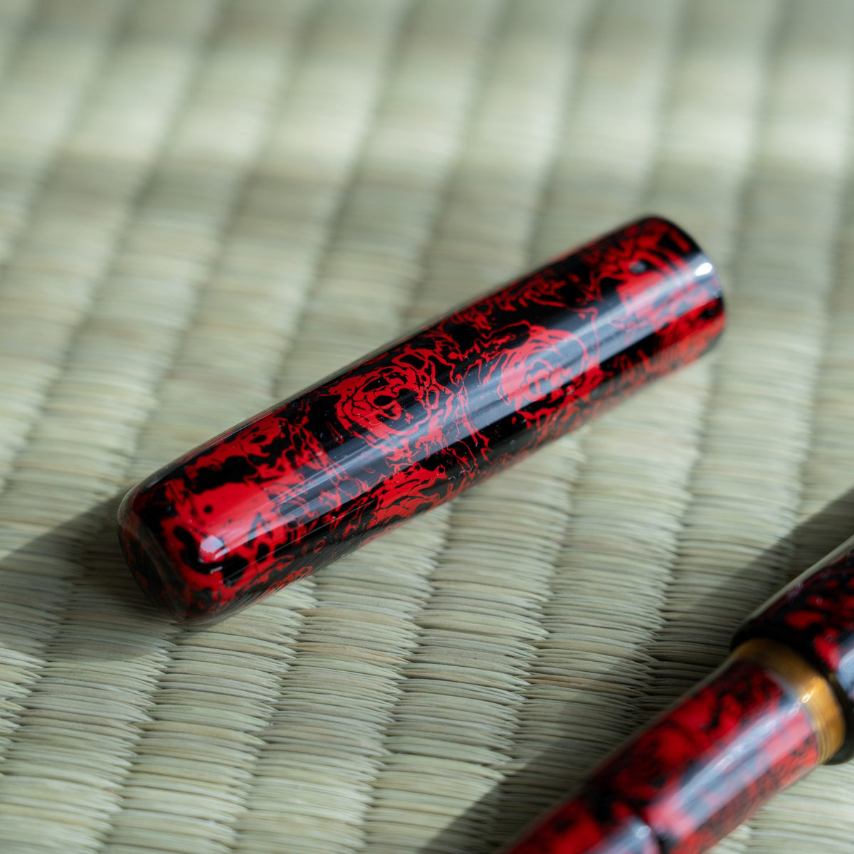 Kagaribi cap on tatami, layered red and black urushi lacquer with a rounded flat top