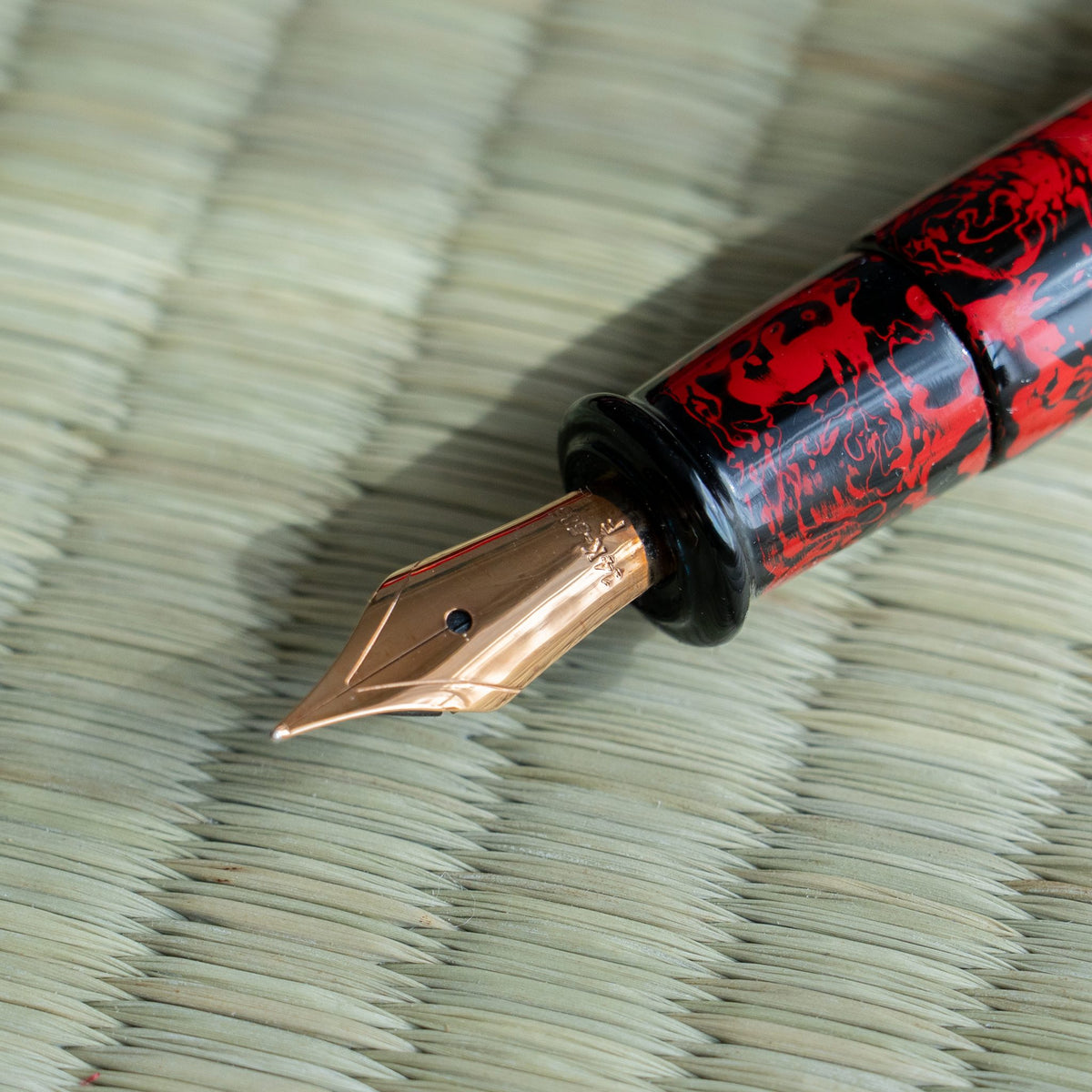 Macro of the Kagaribi 14K gold nib with black section and red and black urushi barrel