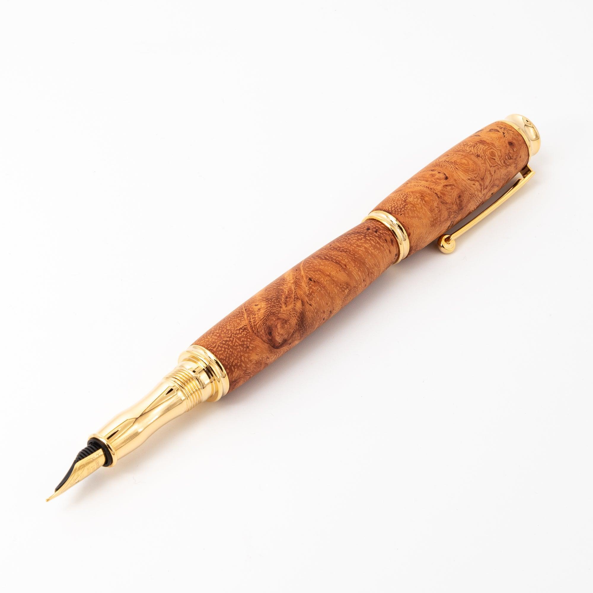 A Japanese fountain pen crafted from luxurious Karin wood with gold accents, displayed open to highlight its nib and smooth design on a white surface.