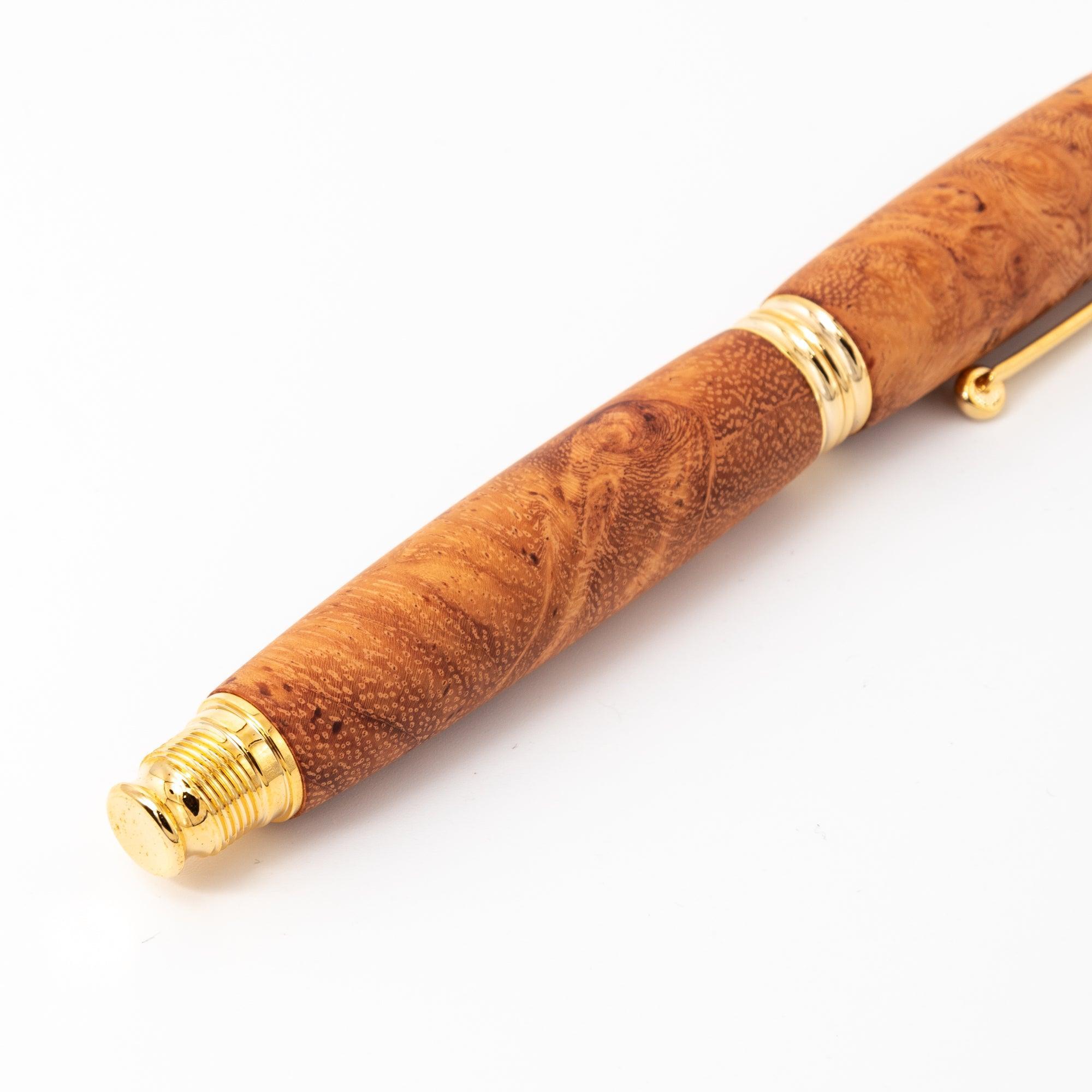 A detailed view of a Japanese fountain pen with a Karin wood barrel and gold screw cap, highlighting its luxurious craftsmanship on a white surface.