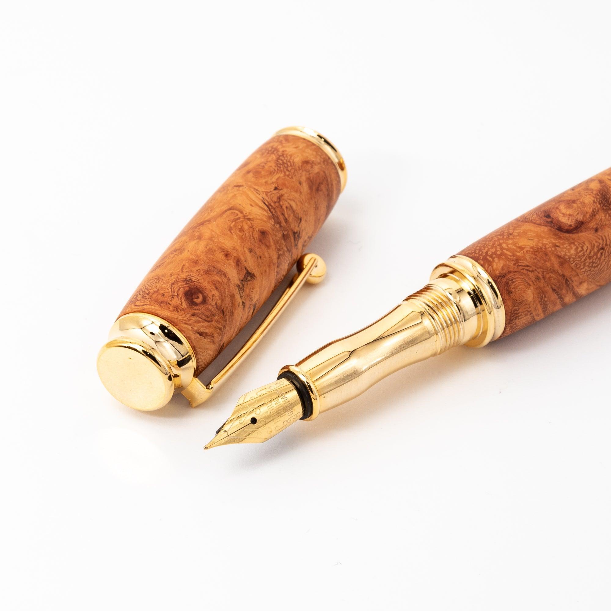 A close-up of a Japanese Karin wood fountain pen showcasing its elegant gold nib, smooth barrel, and luxurious cap on a white surface.