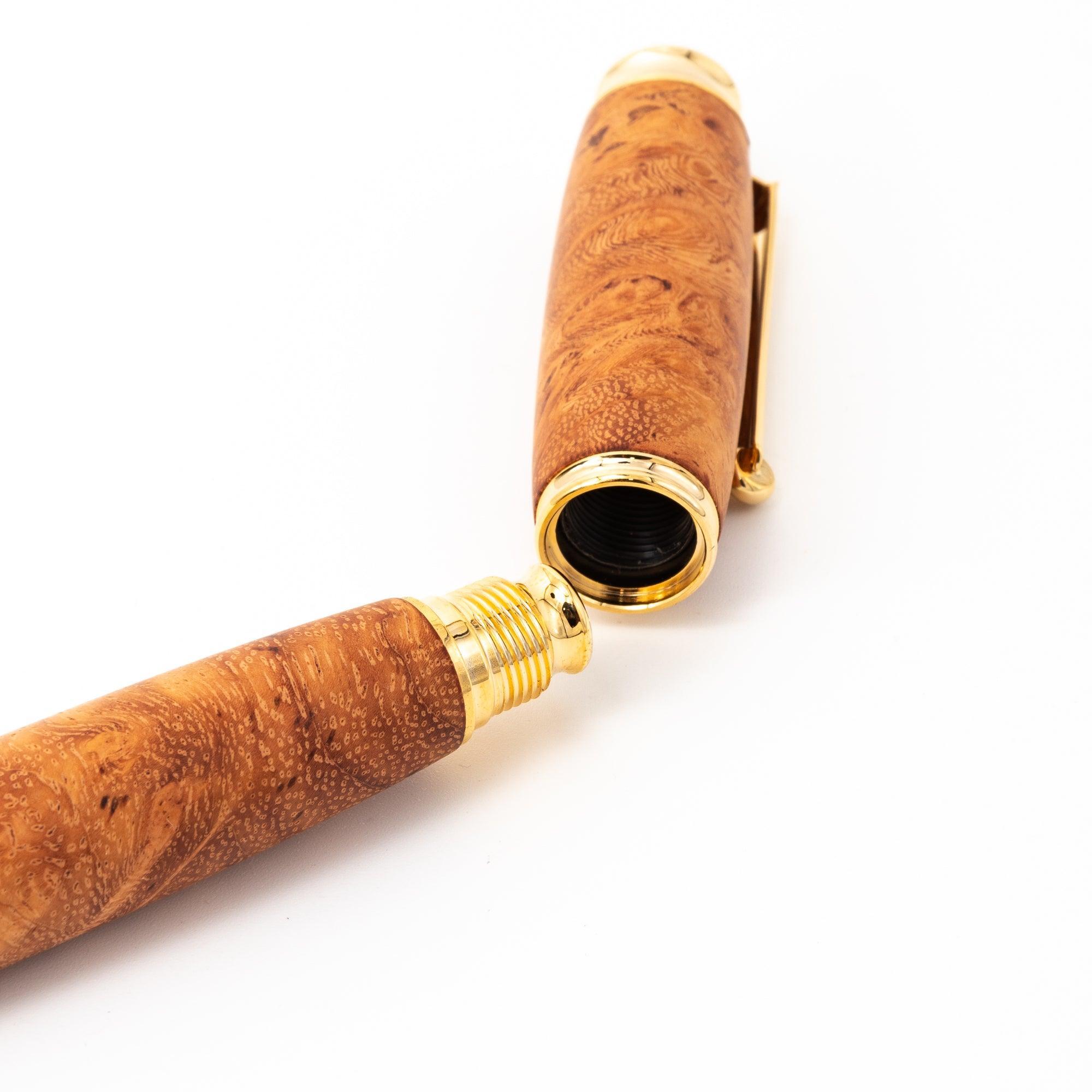 A detailed image of a Japanese fountain pen featuring a Karin wood barrel and gold screw cap mechanism, emphasizing its premium craftsmanship.