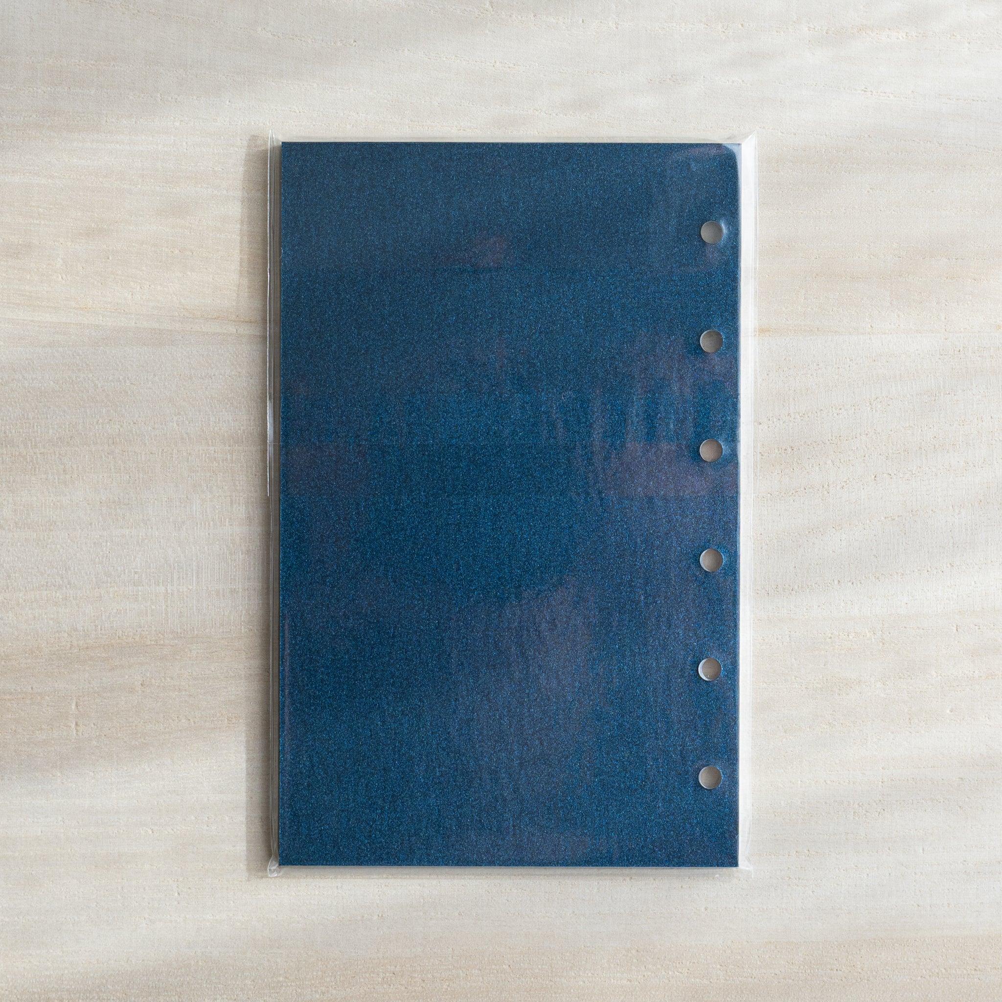 Japanese Stationery blue onion skin Mini 6 refill sheet displayed flat on a desk, showing six punched holes.