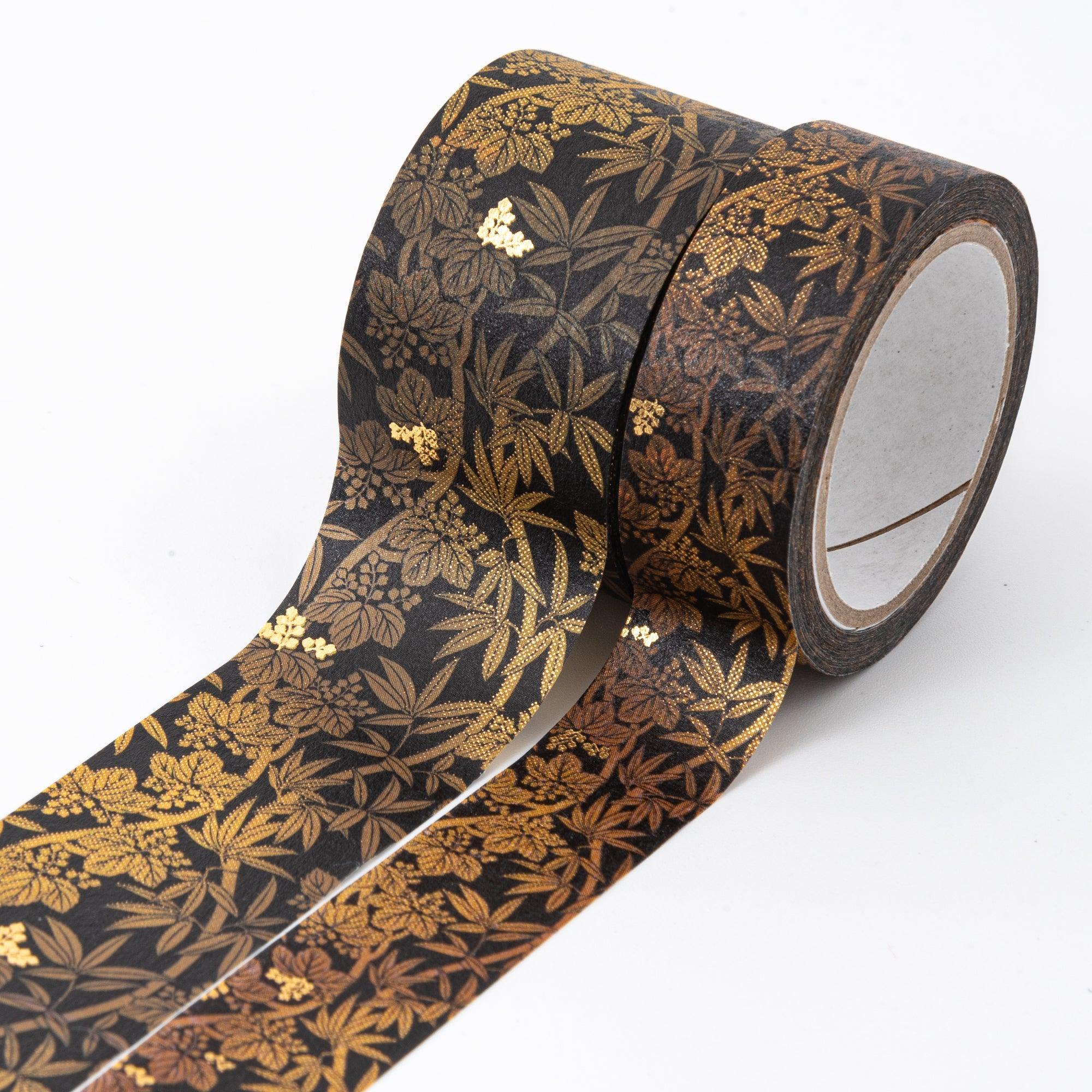 Two black washi tape rolls adorned with gold and bronze bamboo leaf designs, unrolled to display the detailed pattern.