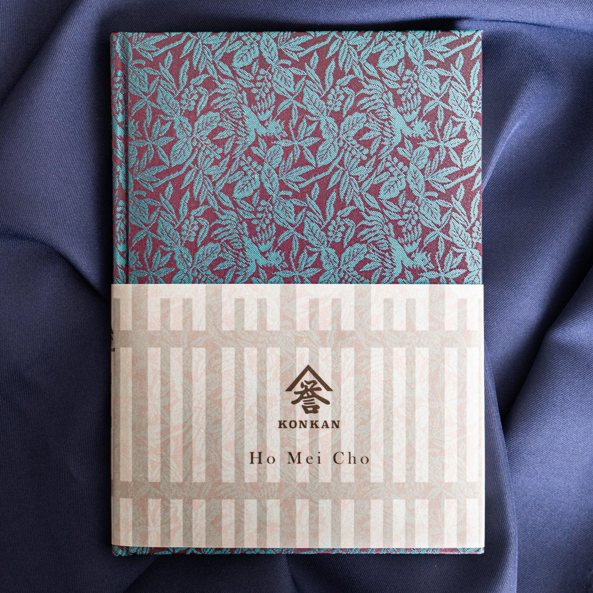 Kiri Take Ho-o Nishijin silk Homeicho notebook with paper band showing Konkan Ho Mei Cho branding on blue fabric