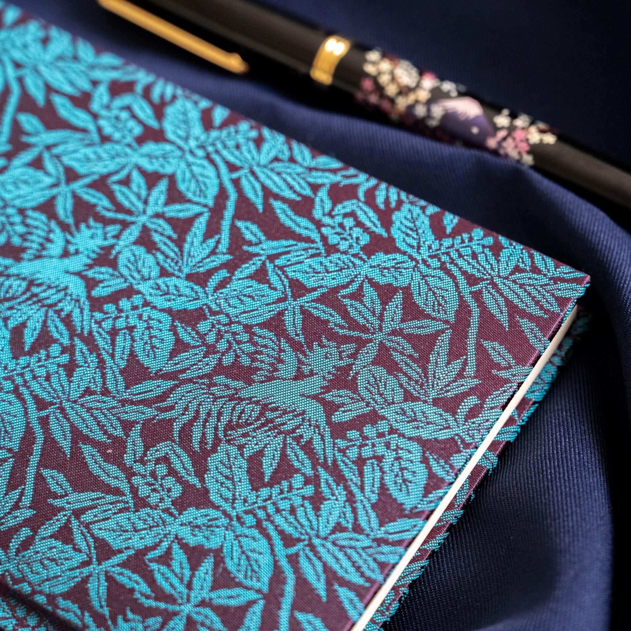 Kiri Take Ho-o Nishijin silk notebook cover close-up with maki-e pen across top showing gold and floral decoration