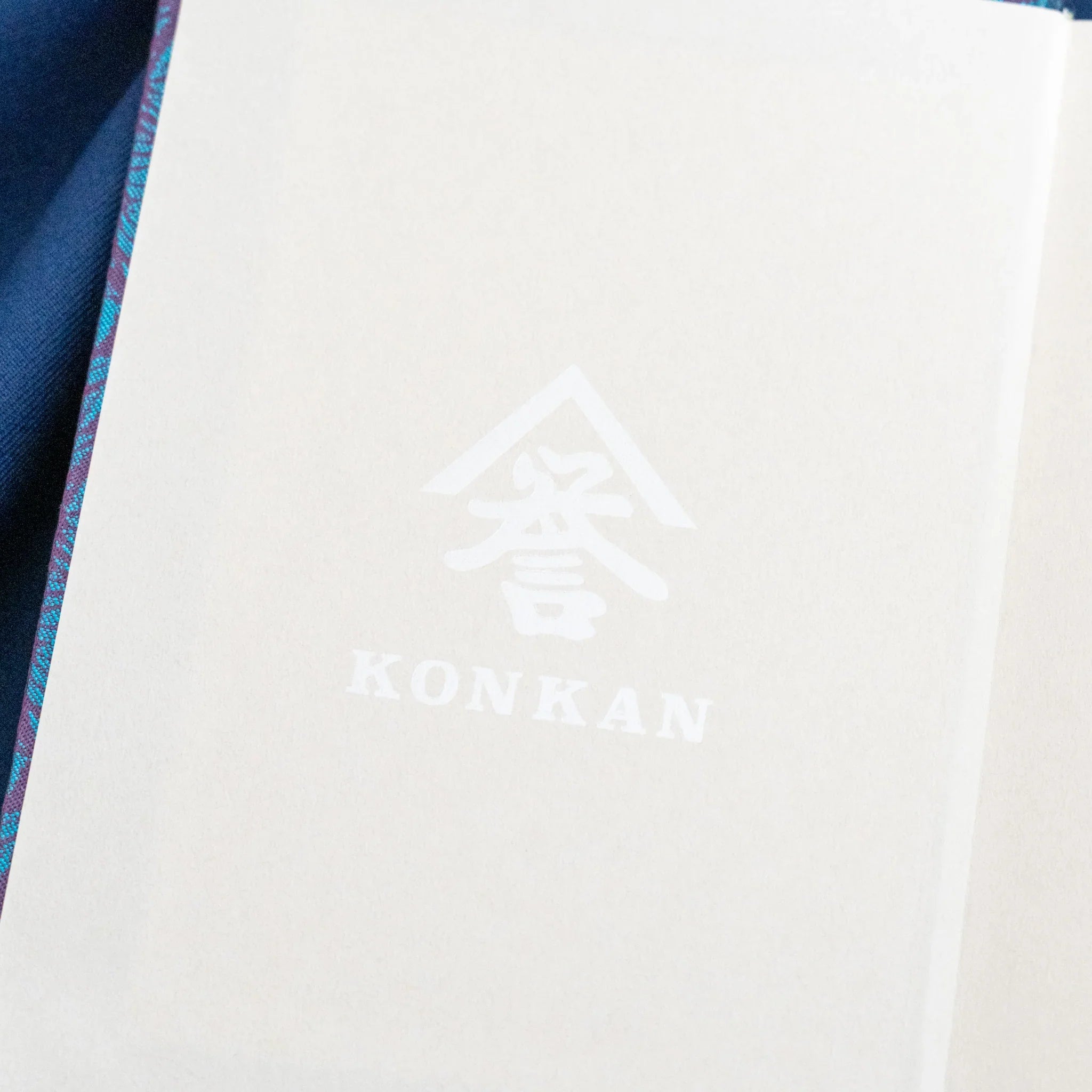 Kiri Take Ho-o Nishijin silk notebook interior showing Konkan brand watermark on white page with teal cover at left