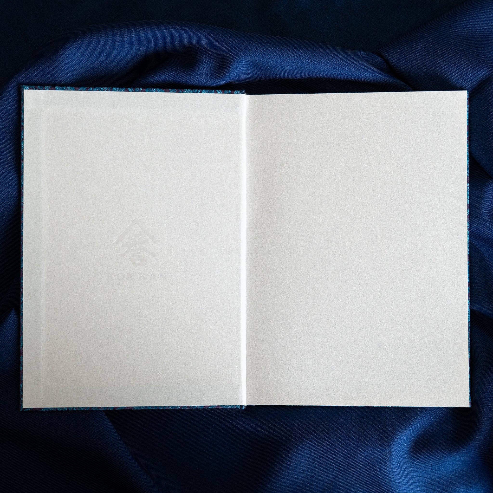 Kiri Take Ho-o Nishijin silk Homeicho notebook open flat showing blank white pages with teal woven cover at spine