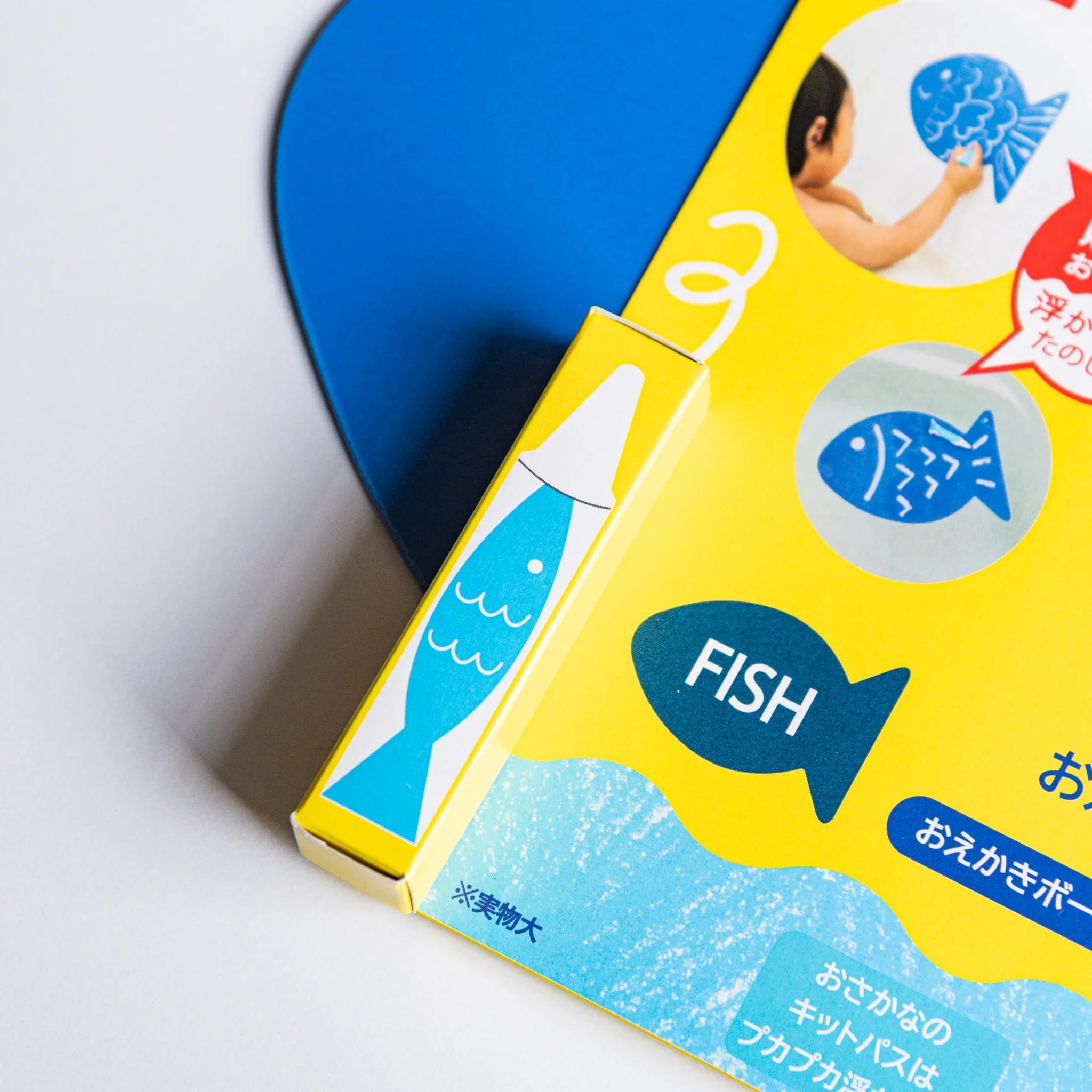 Kitpas bath drawing board packaging with yellow box featuring blue fish design and part of the blue fish board.