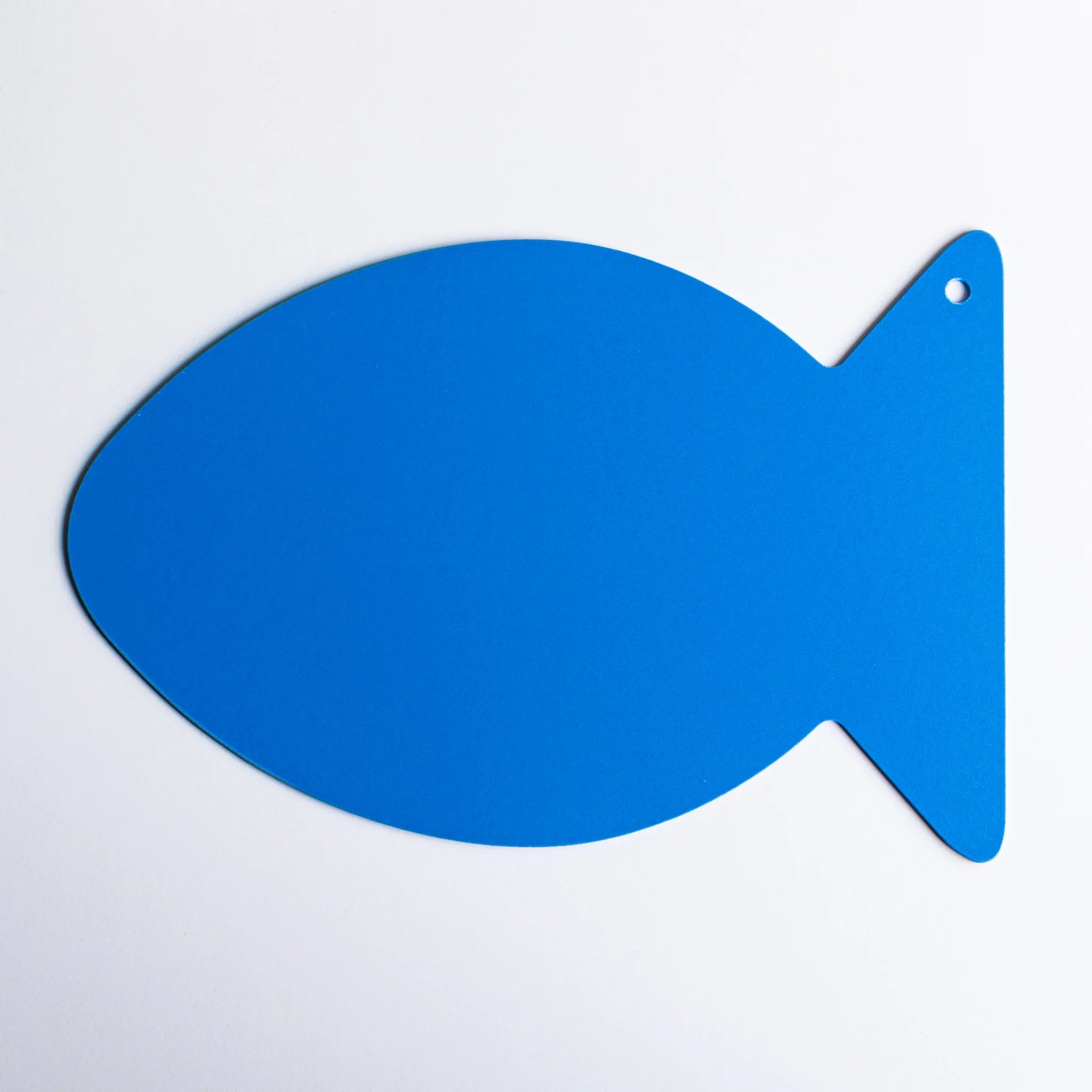 Blue fish-shaped kitpas bath drawing board against a white background, highlighting the board’s simple silhouette.