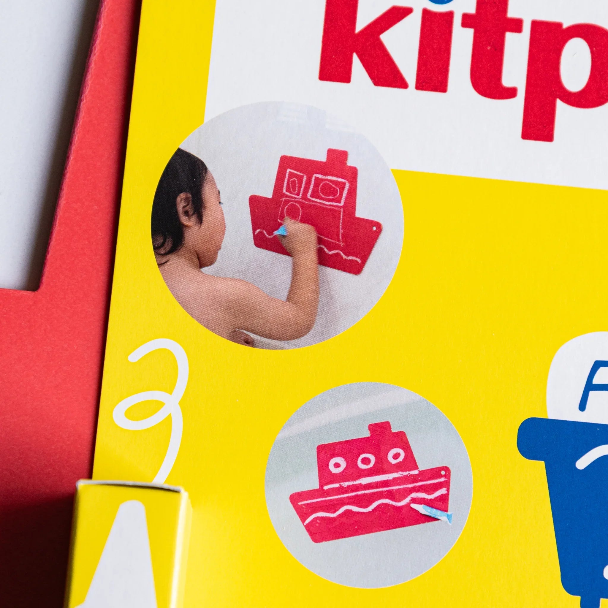 Kitpas bath drawing board packaging showing a child drawing on the red ship-shaped board and a smaller ship image.