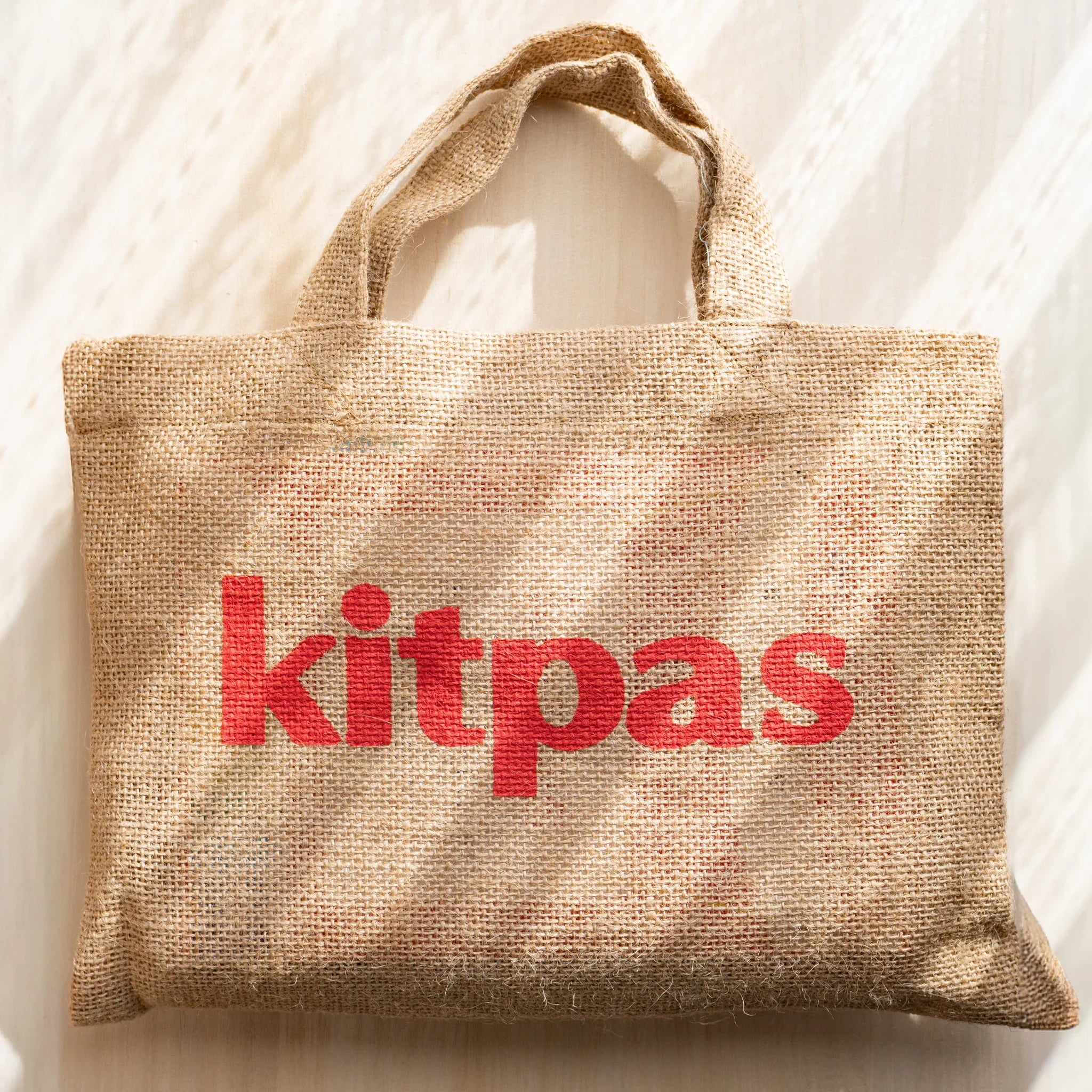 Kitpas watercolor crayons arranged in the original linen storage bag with handles showing closed position