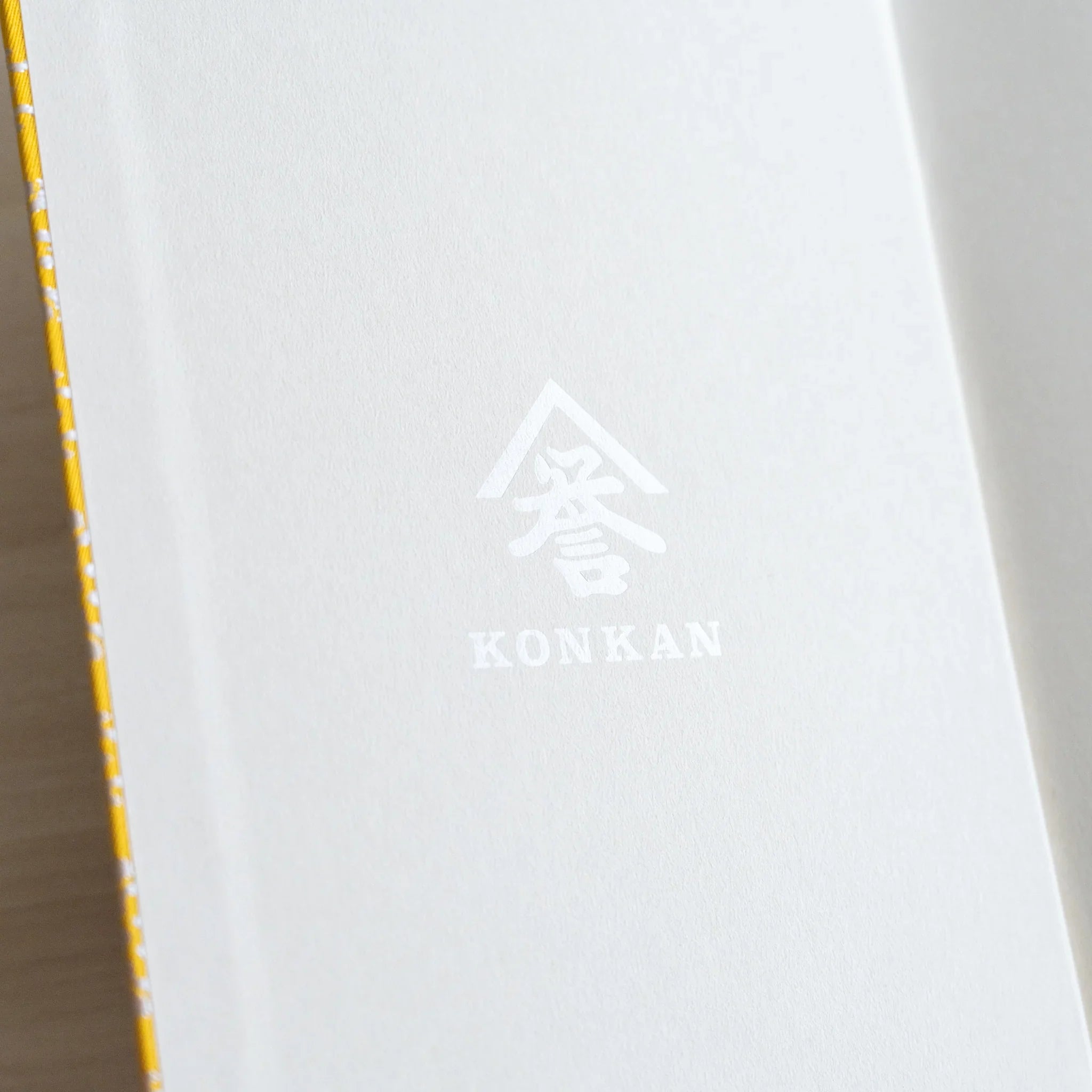 Ko Aoi Nishijin silk Homeicho notebook interior showing white endpaper with KONKAN logo embossed on inner cover