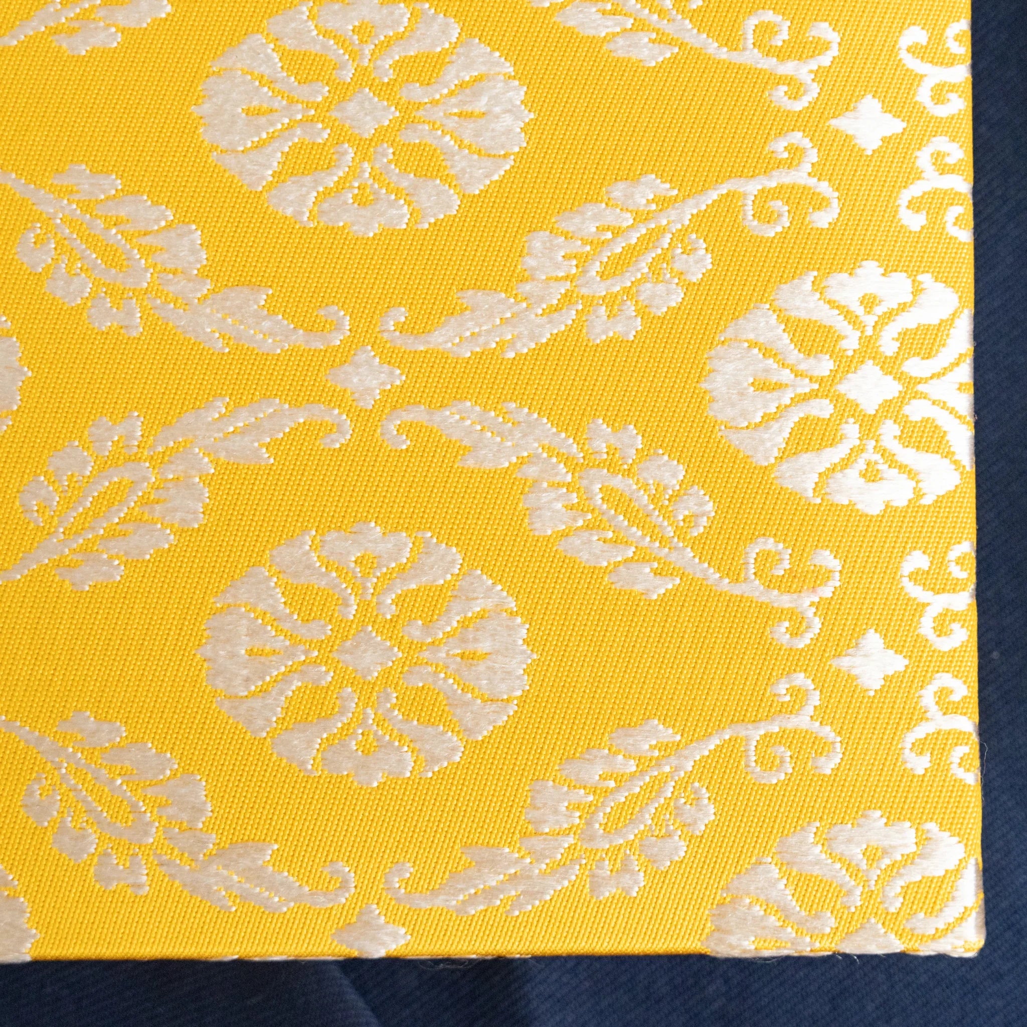 Ko Aoi Nishijin silk Homeicho notebook cover close-up showing golden Ko Aoi pattern with spine edge on navy fabric