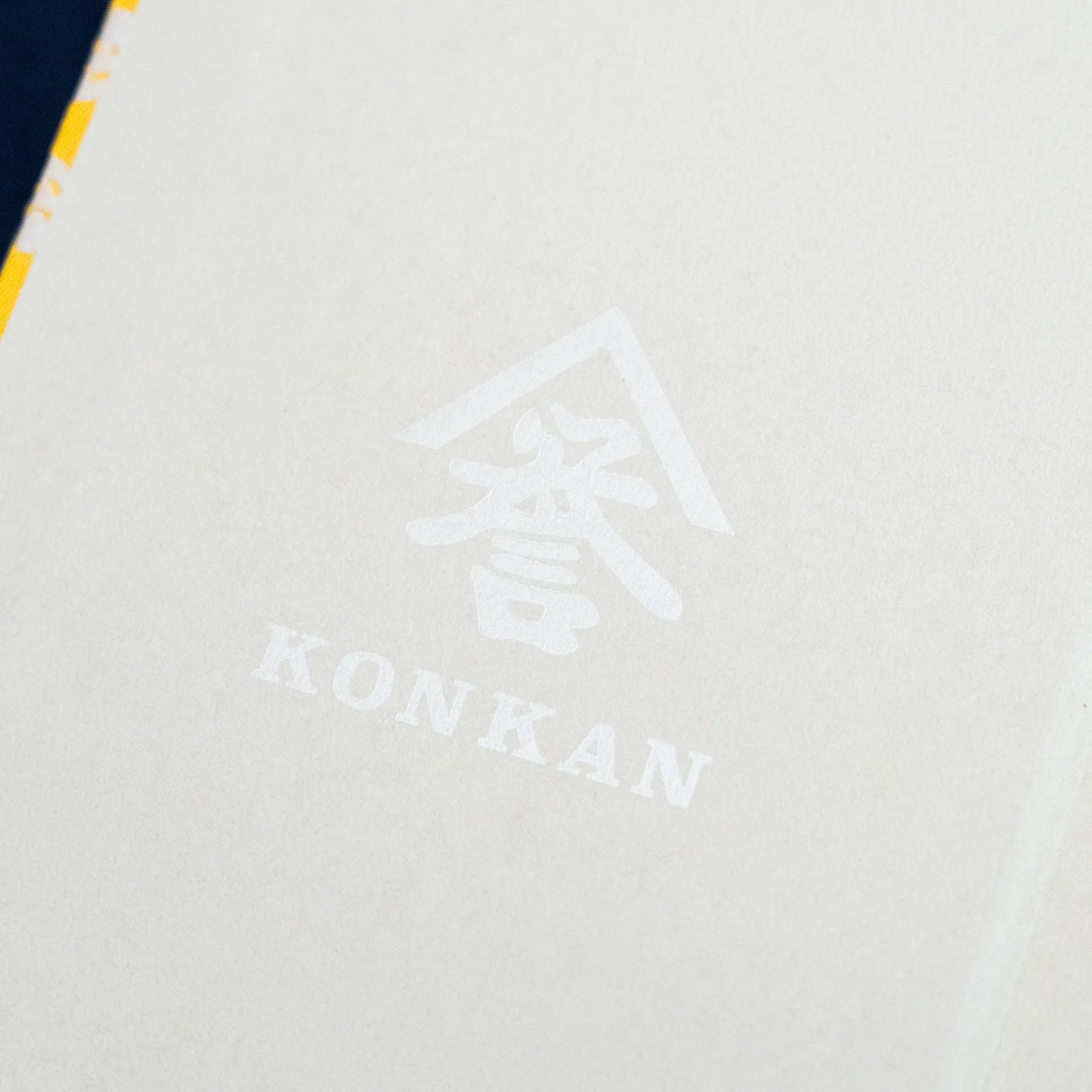 Ko Aoi Nishijin silk Homeicho notebook opened to inner cover showing large KONKAN watermark logo on cream endpaper