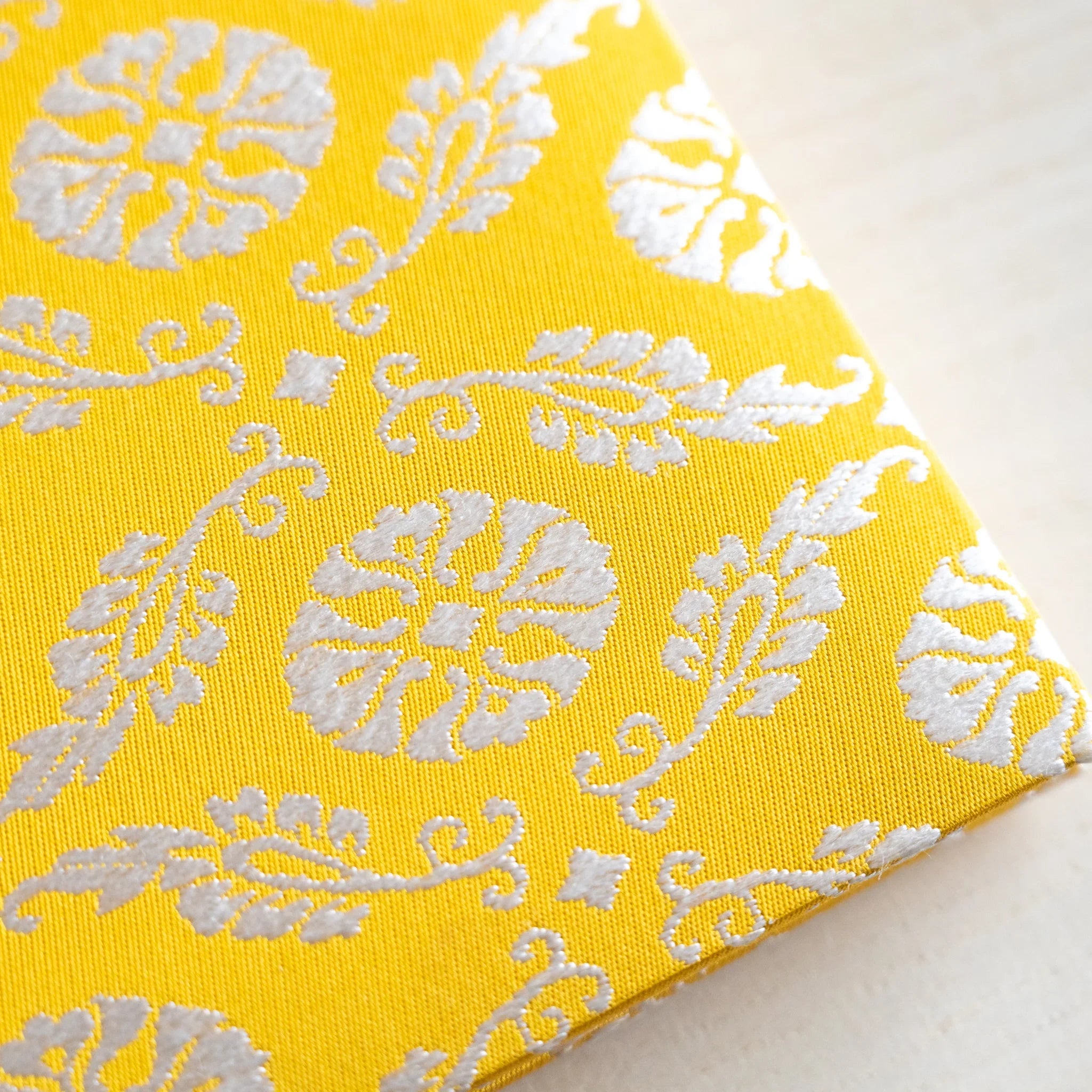 Ko Aoi Nishijin silk cover close-up showing golden yellow background with cream chrysanthemum and leaf weave motifs