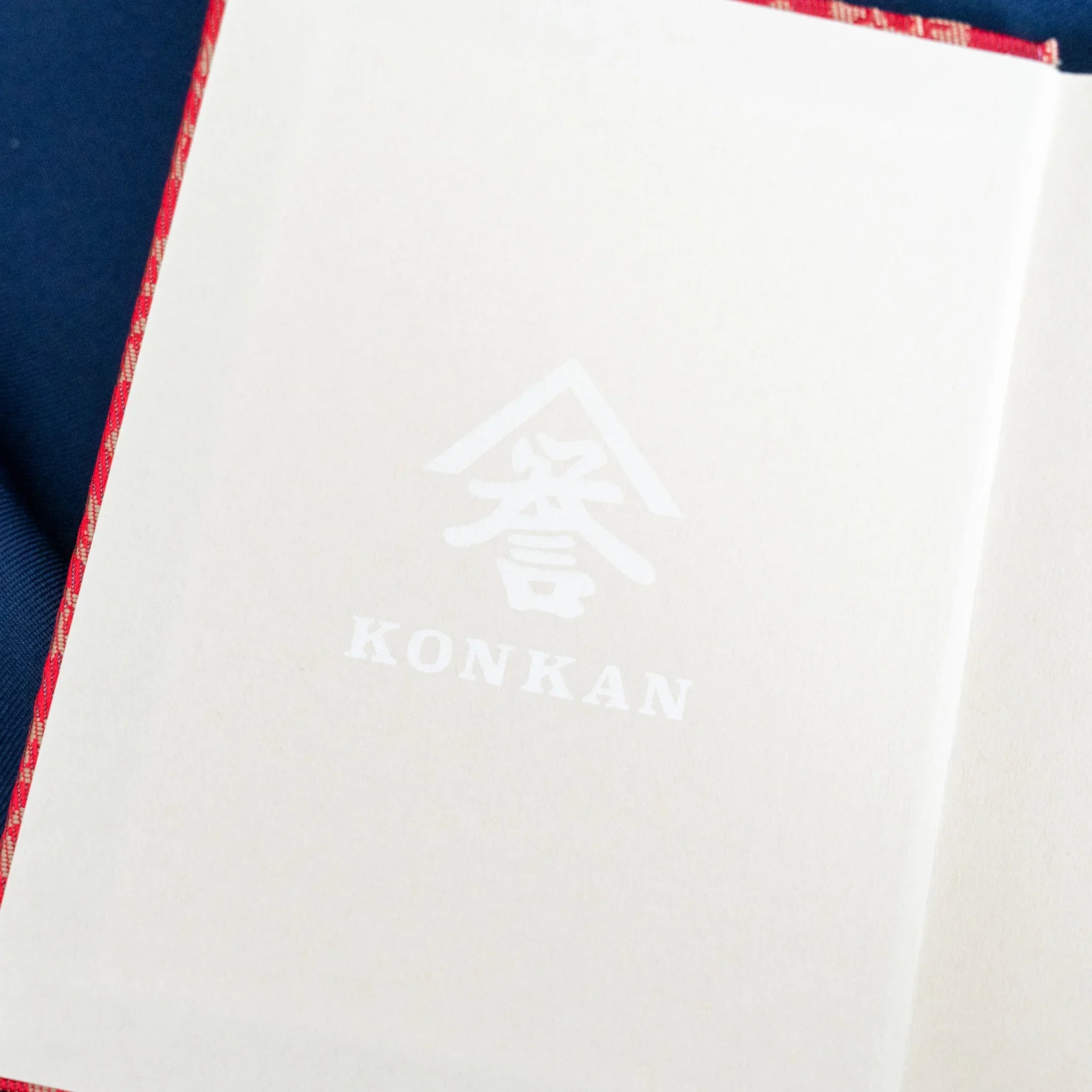 Ko Aoi Nishijin silk Homeicho notebook interior showing white endpaper with KONKAN logo embossed on inner cover