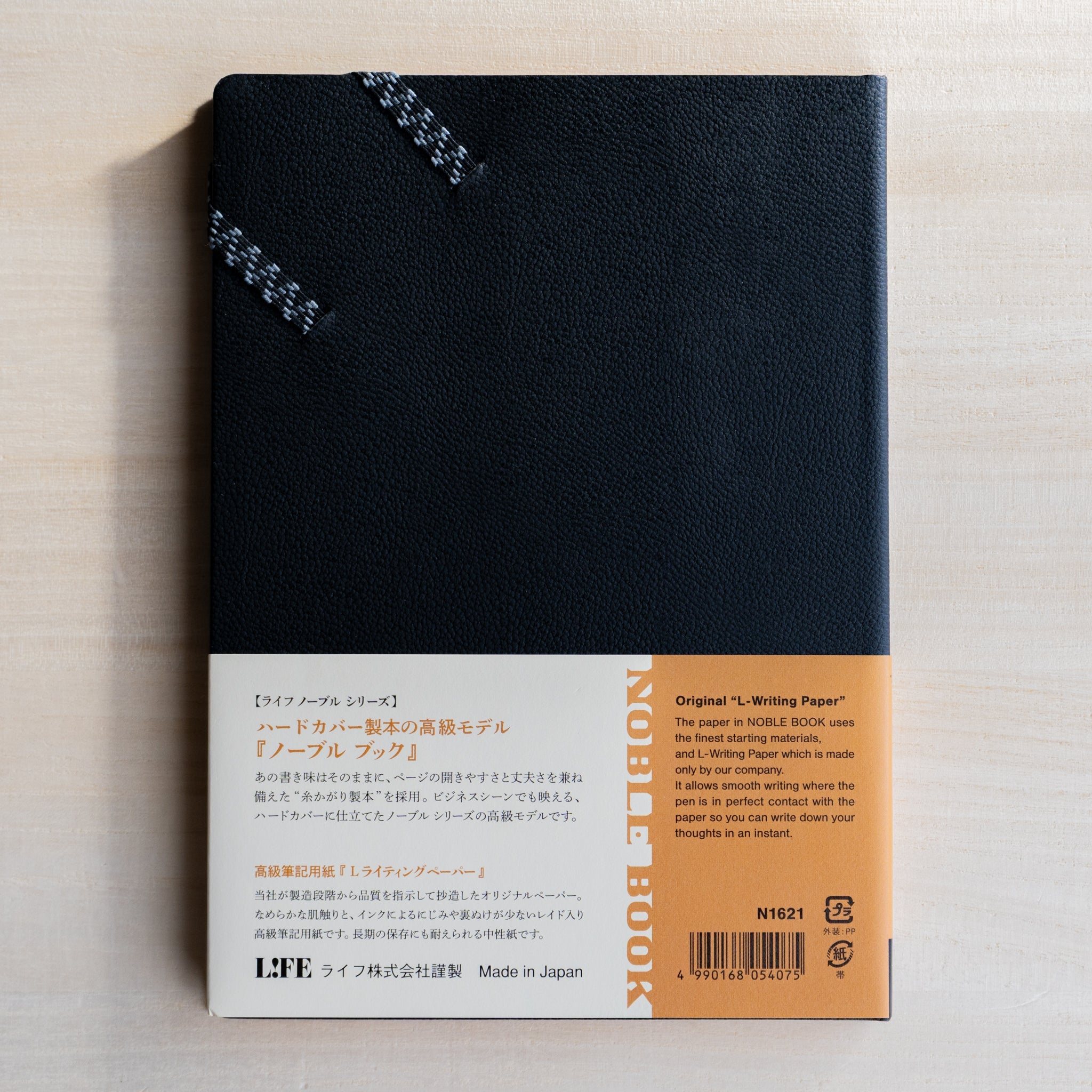 Life noble hard cover notebook A5 back view shown flat, black textured cover with paper belly band and product details