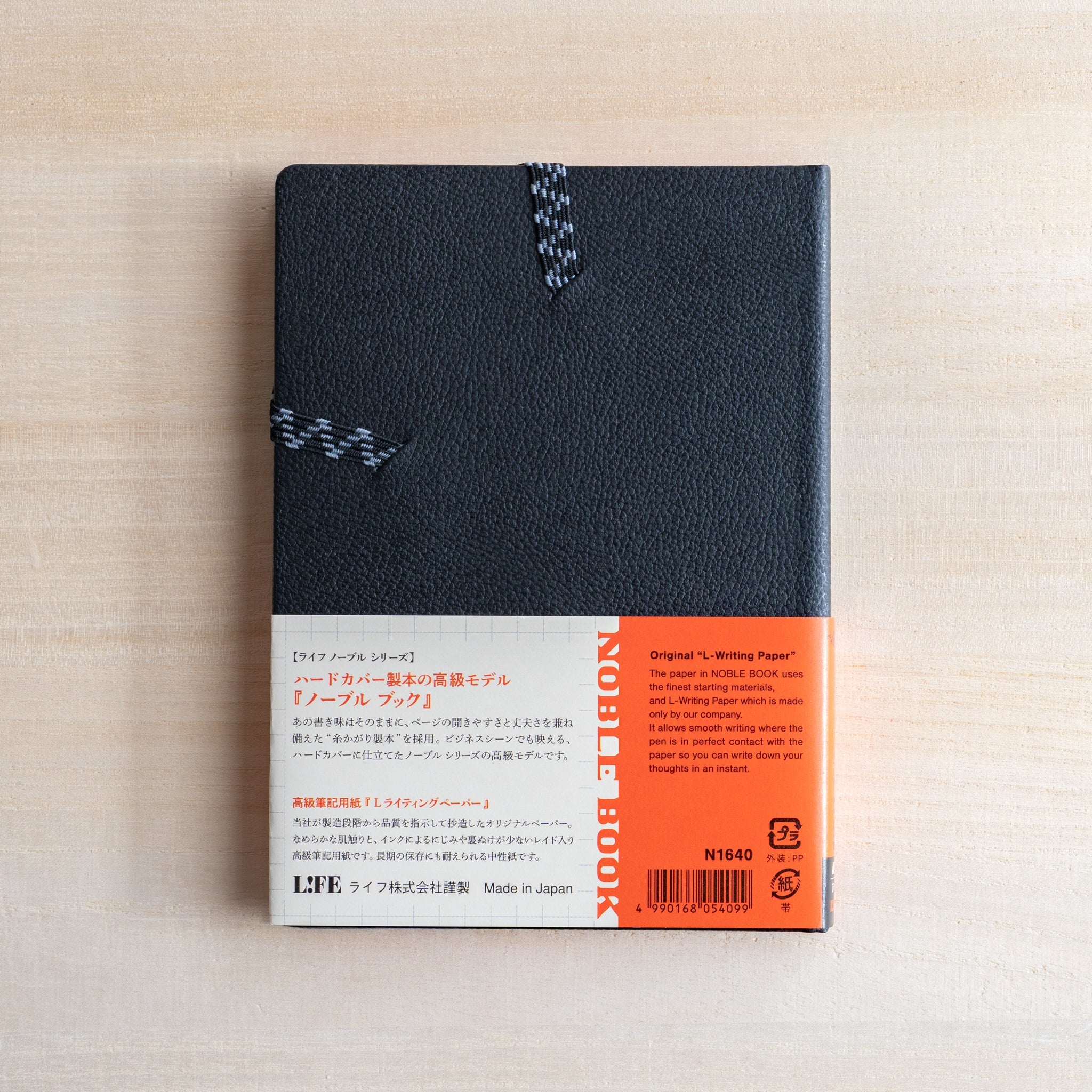 Life Noble notebook A6 back cover on desk with orange product label and textured hard cover