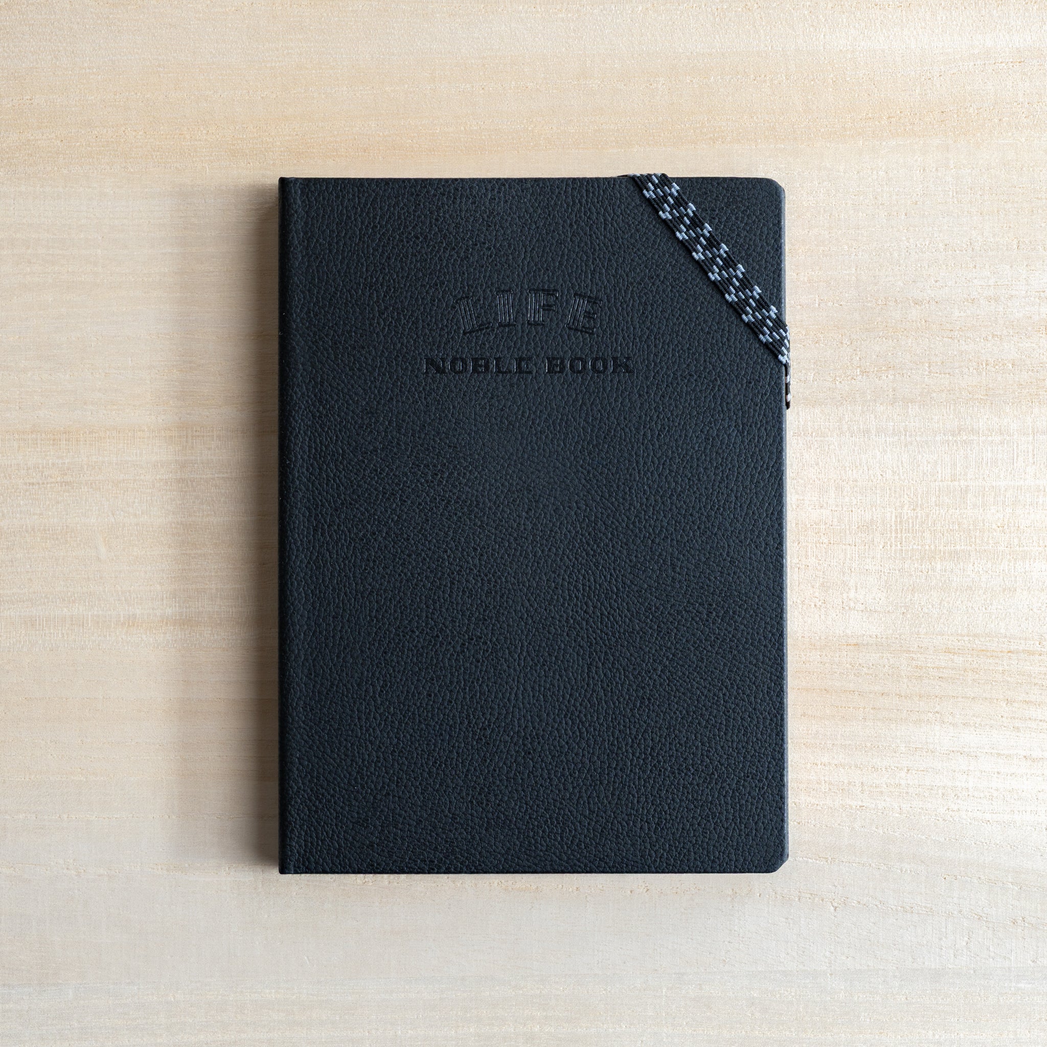 Life Noble notebook A6 open on desk, highlighting cream L Writing Paper texture and compact size for everyday writing
