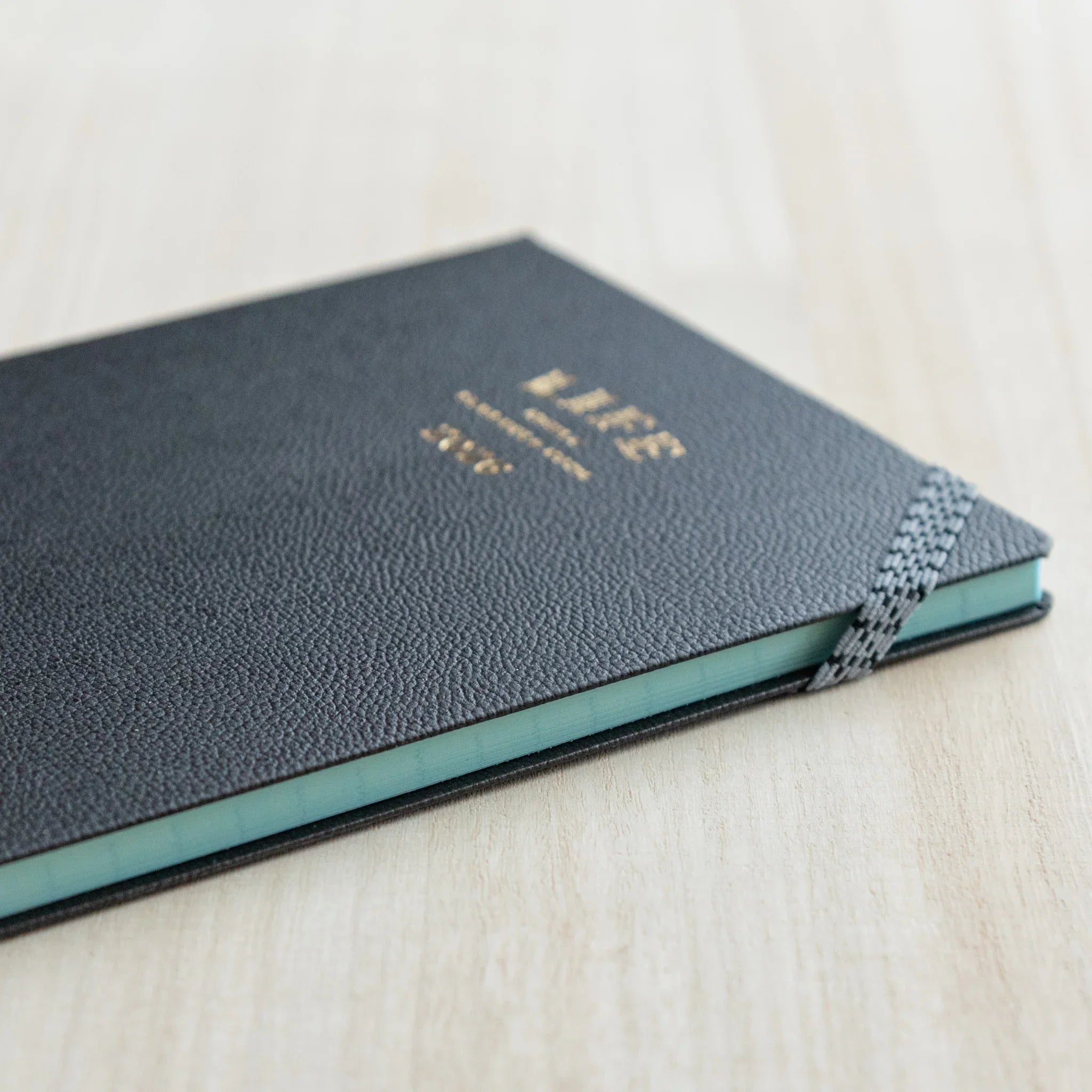 Side view of the LIFE Noble Planner 2026 showing mint-colored page edges, a refined Japanese Planner.