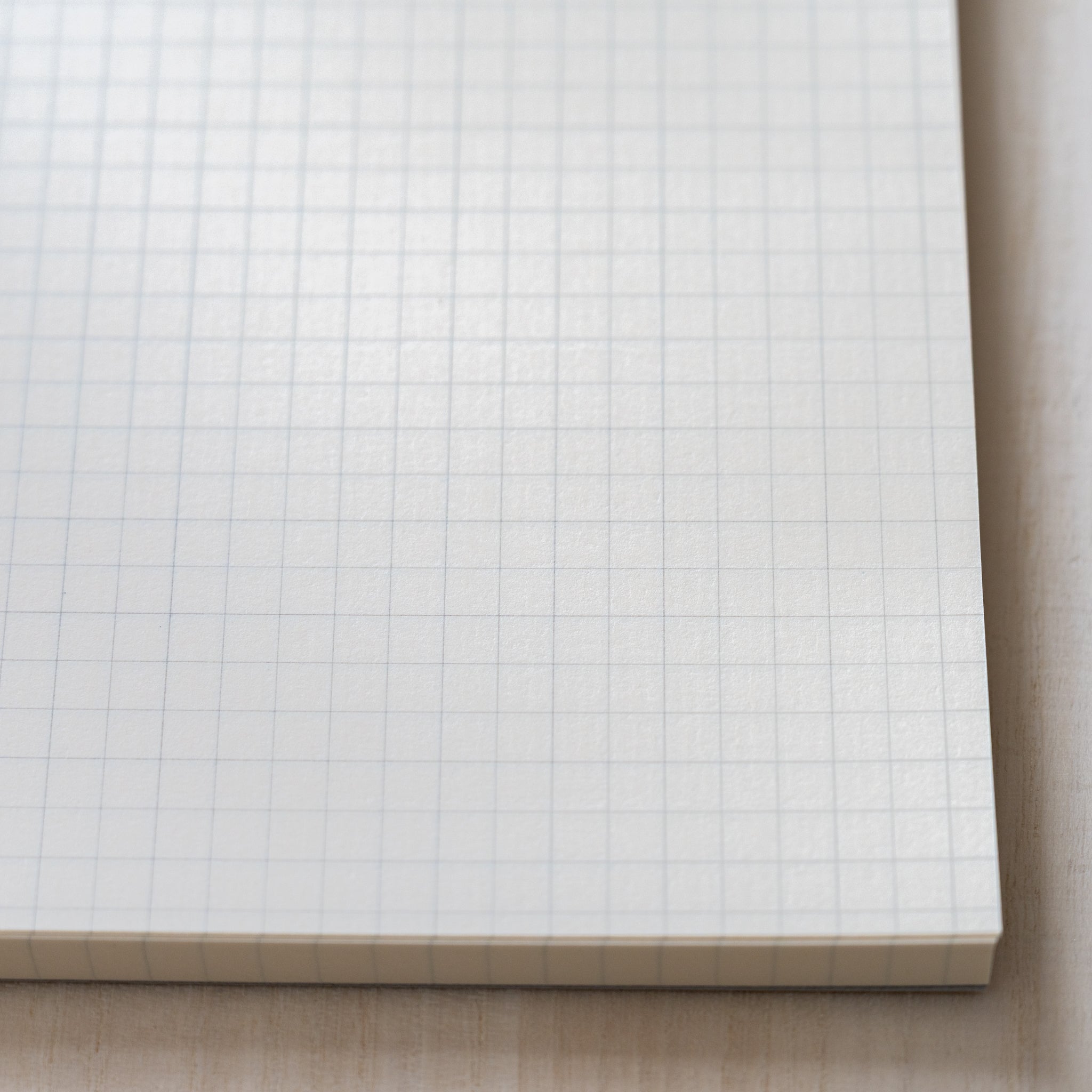 Life Noble writing pad grid paper close-up showing even squares and soft cream tone, Japanese stationery pad for precise writing