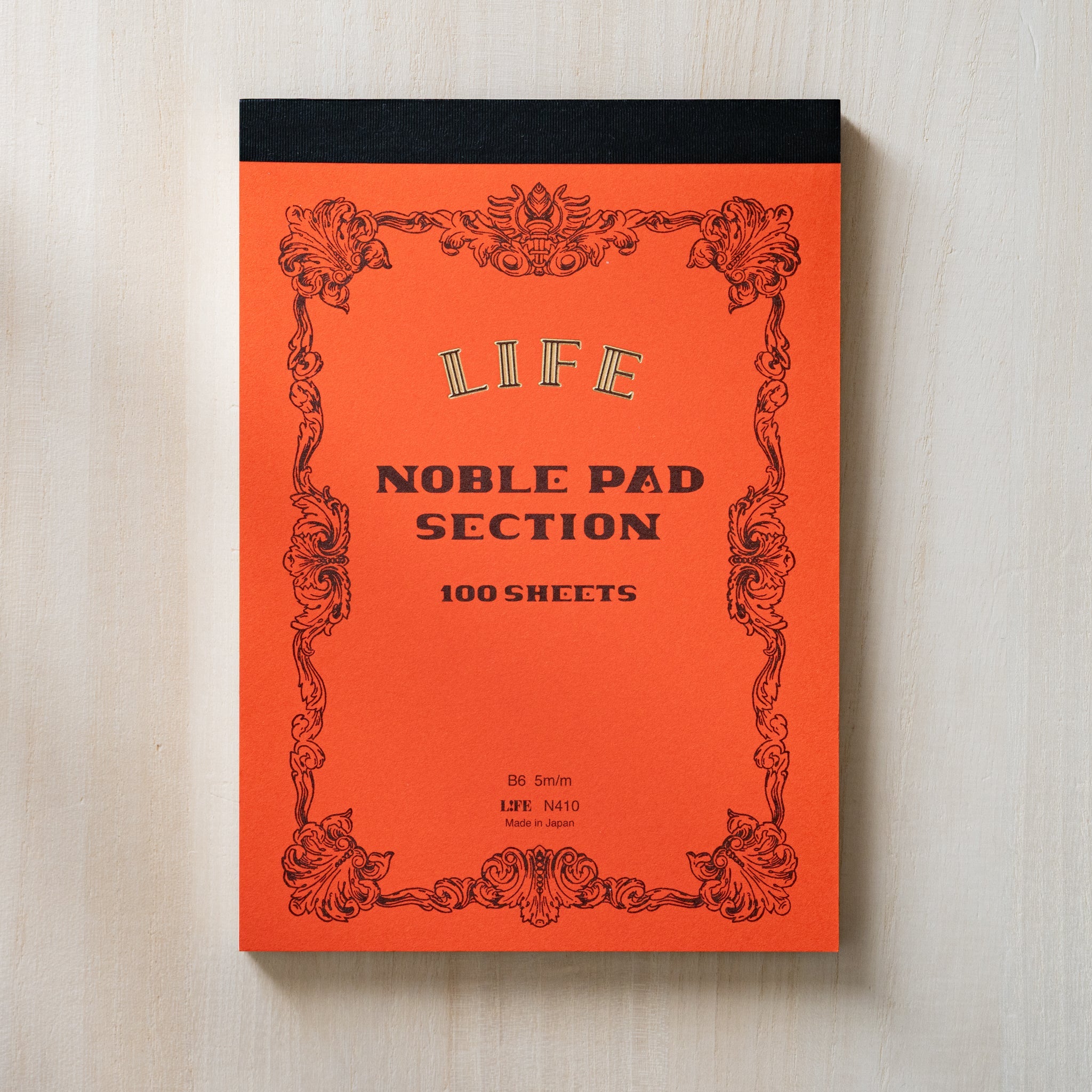 Life noble writing pad B6 front cover showing orange Noble Pad Section design, black top binding and vintage frame details