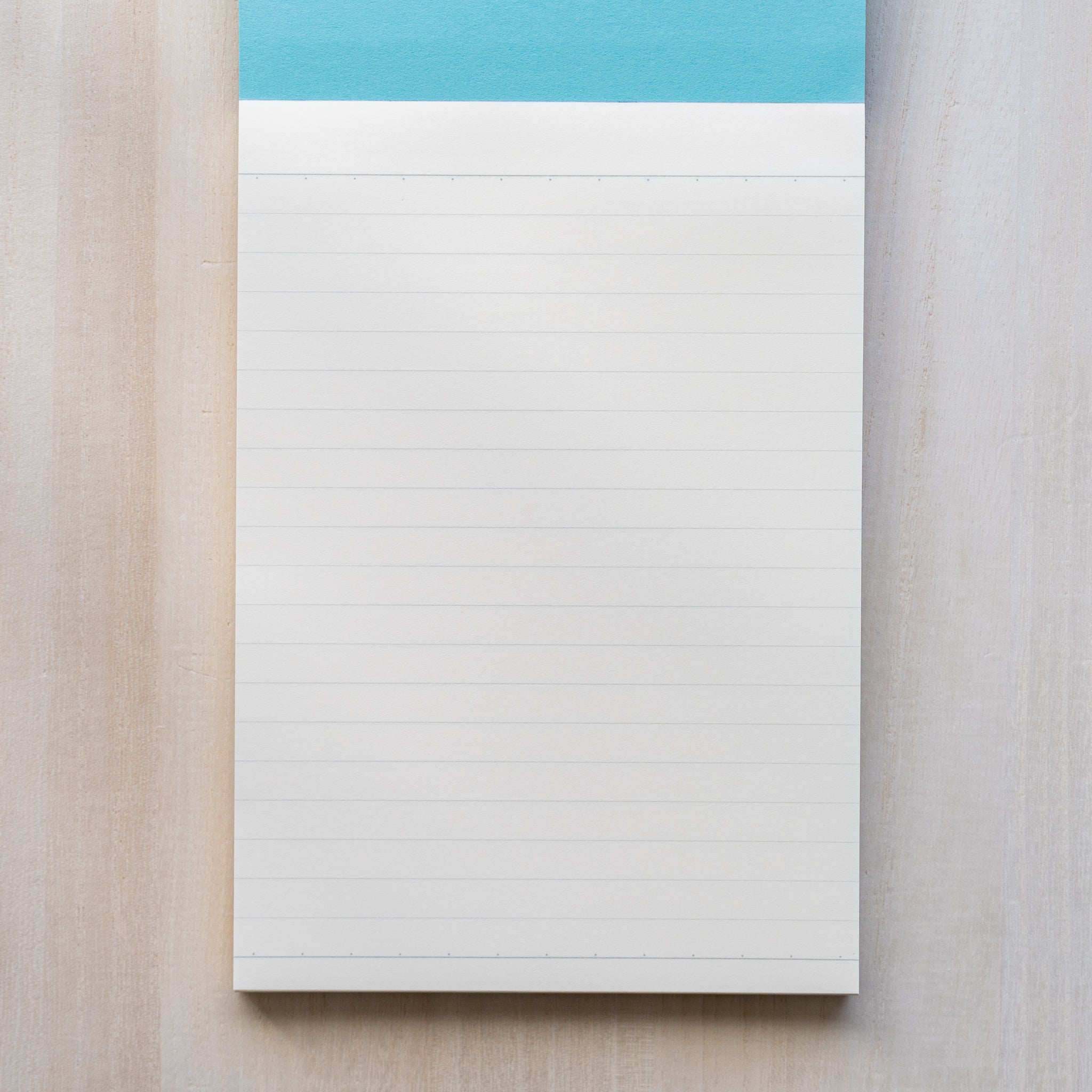 Life noble writing pad B6 ruled page shown from above, cream L Writing Paper with light blue header and fine horizontal lines