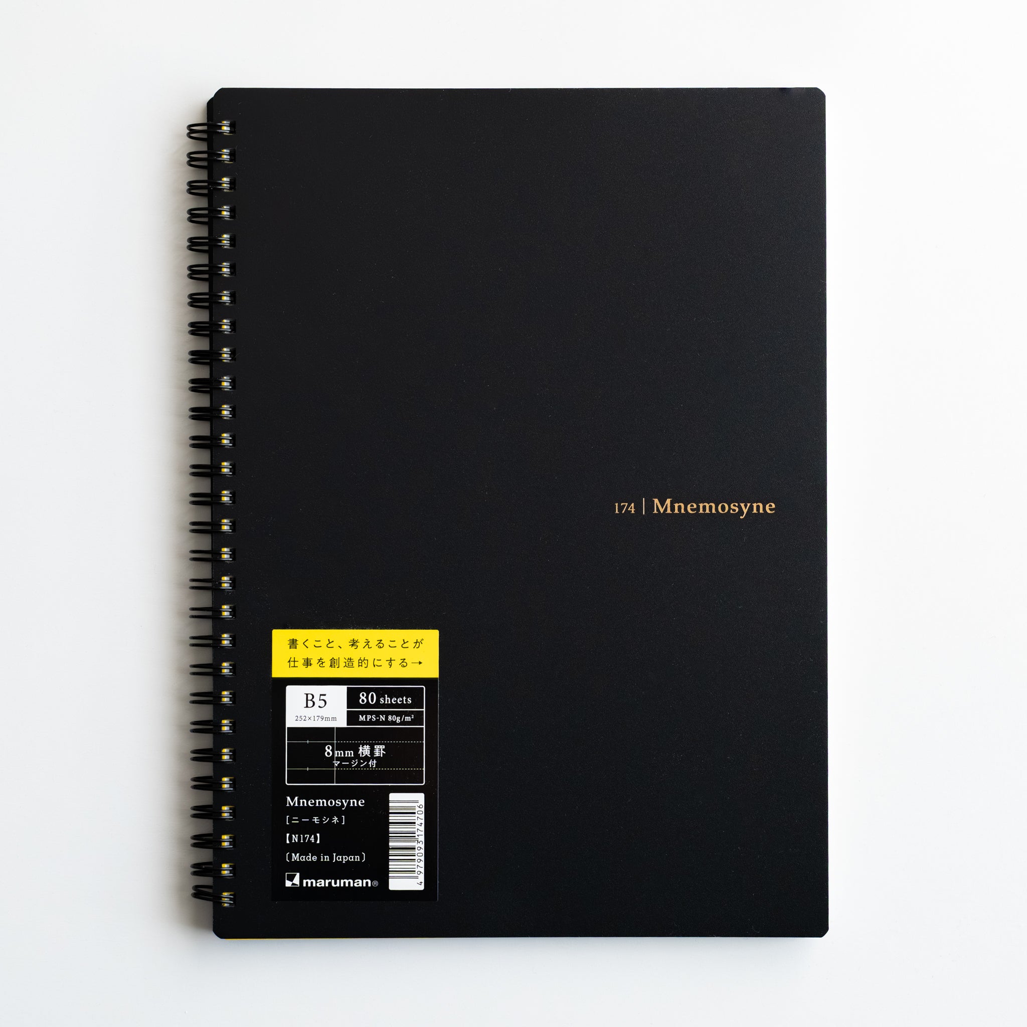 Maruman Mnemosyne lined notebook with black cover, gold logo and yellow product label, featuring twin-ring binding.