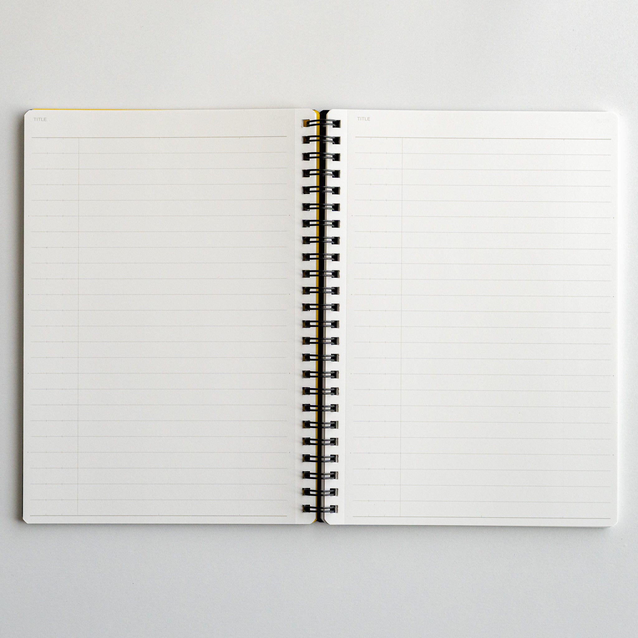 Open Mnemosyne lined notebook displaying two blank white pages with spiral binding, ideal for organized writing and notes