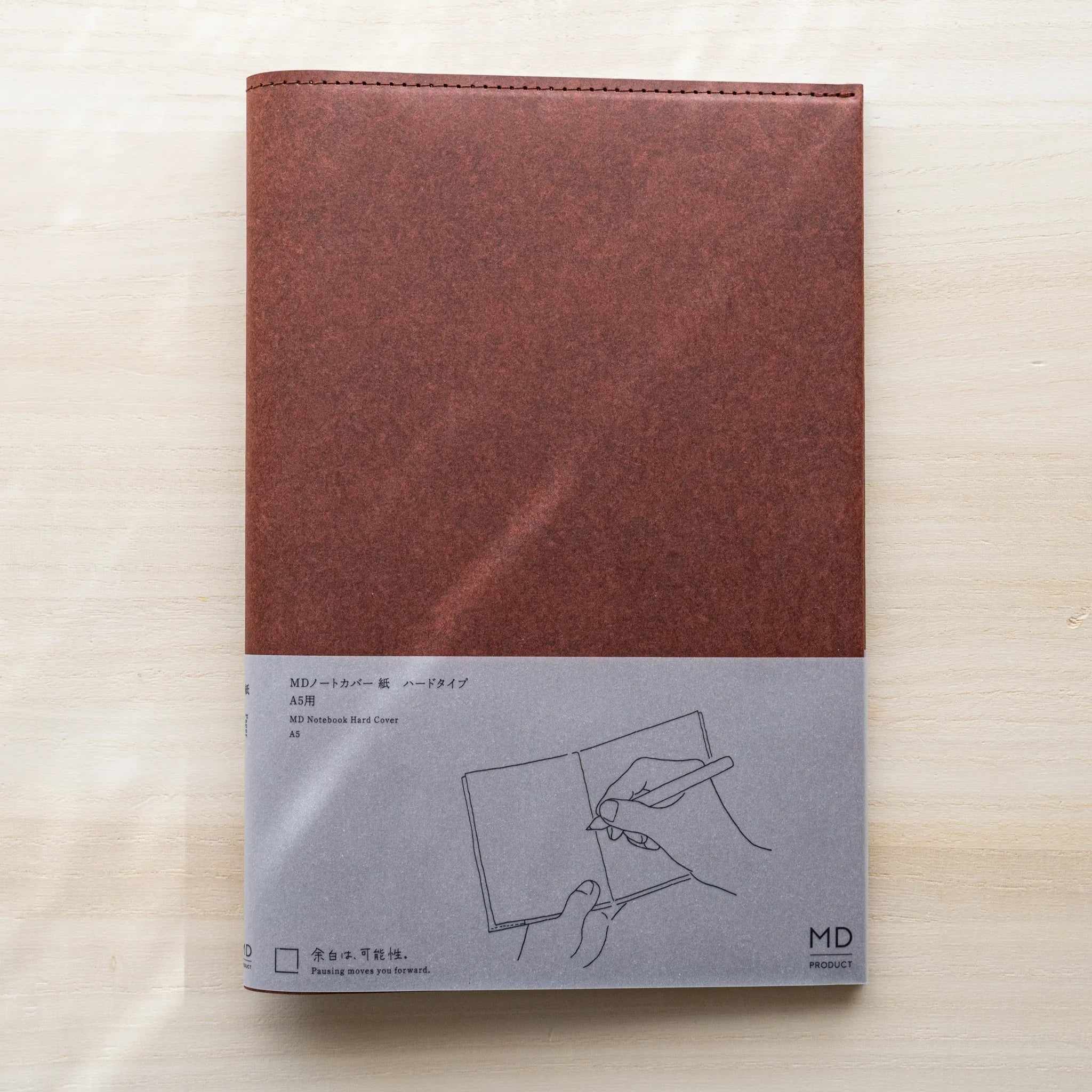 Midori MD Notebook Hard Cover A5, dark red hard paper, gray belly band with hand writing illustration and MD Product logo