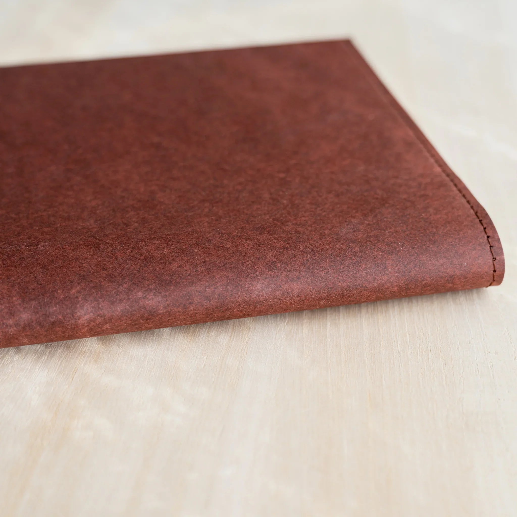 Midori MD Notebook Hard Cover bottom-right corner close-up, dark red hard paper texture with black stitched right edge