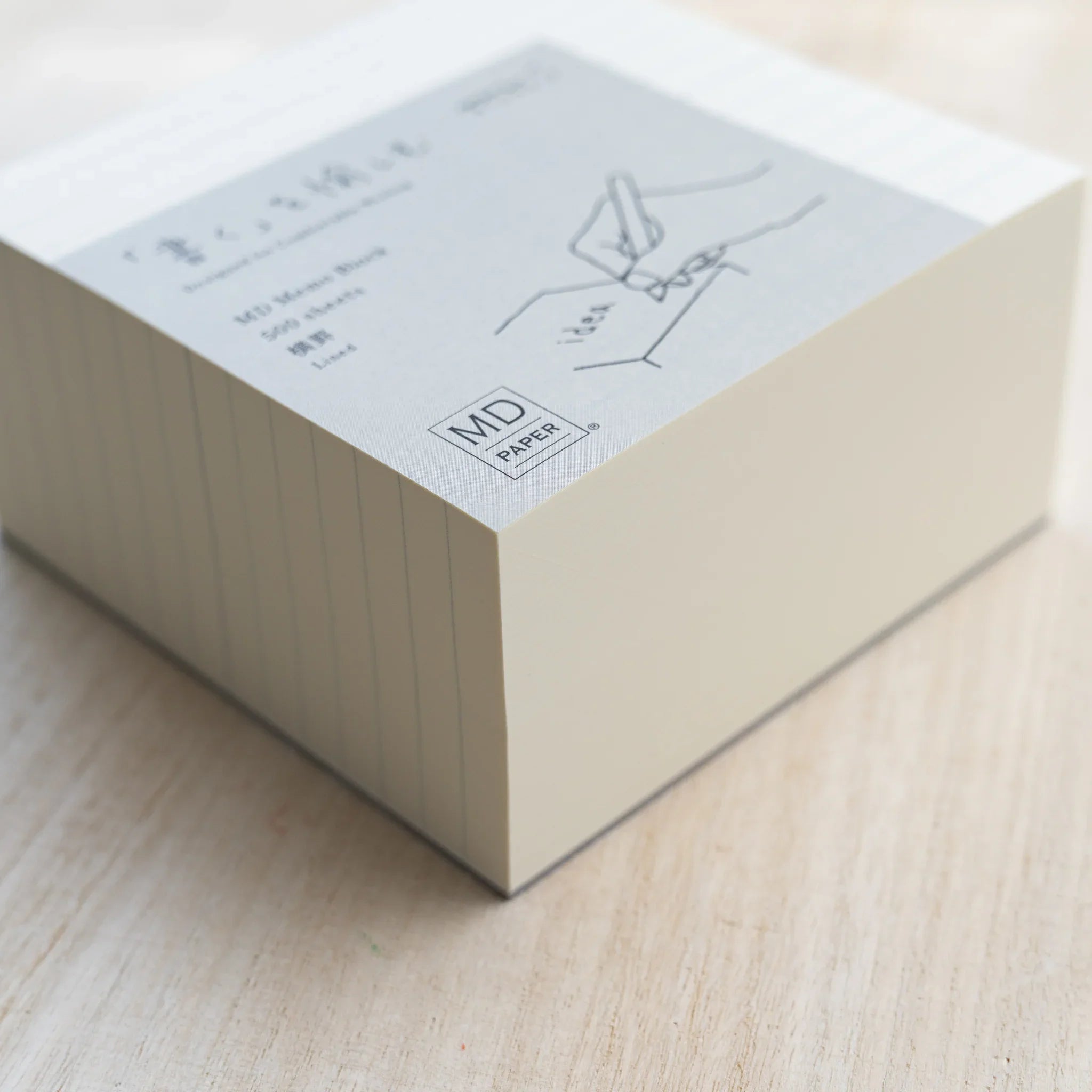 Angled MD Memo Block lined type, cream paper with gray wrap reading MD Memo Block 500 sheets Lined and MD Paper logo